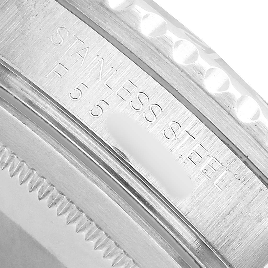 The image shows a close-up of the case side of the Rolex GMT-Master 16710 Men's Stainless Steel Black Dial, highlighting the engraved text on the stainless steel surface.