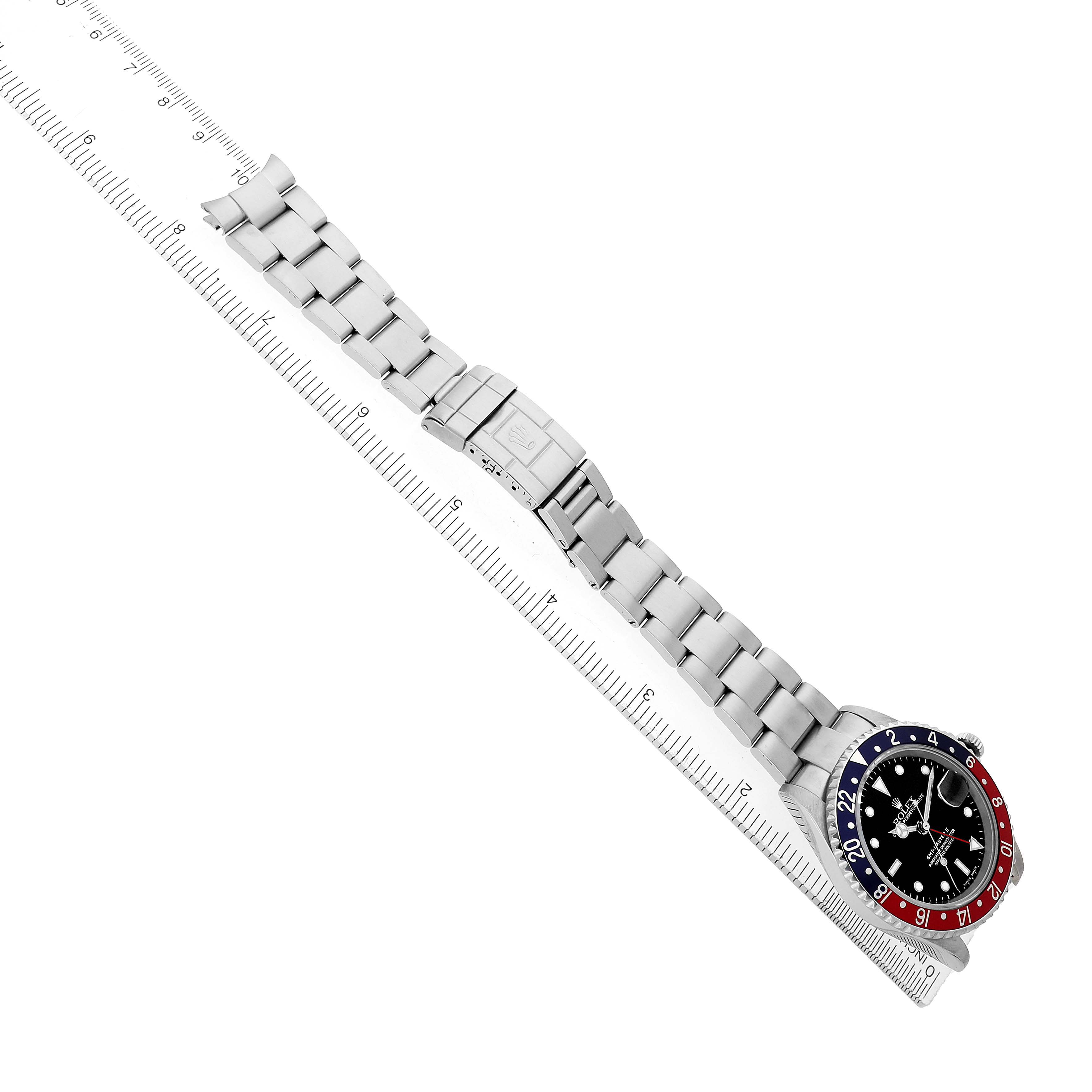 The Rolex GMT-Master 16710 Men's Stainless Steel Black Dial watch is shown from a top view, displaying its bracelet, clasp, case, and bezel aligned with a ruler.