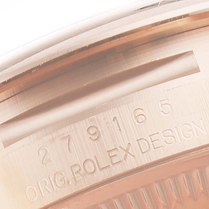This is a close-up of the engraved bezel of a Rolex President 279165 Women's Rose Gold Brown Dial 279165 Women's Rose Gold Brown Dial model showing part of the serial number and "ORIG. ROLEX DESIGN."