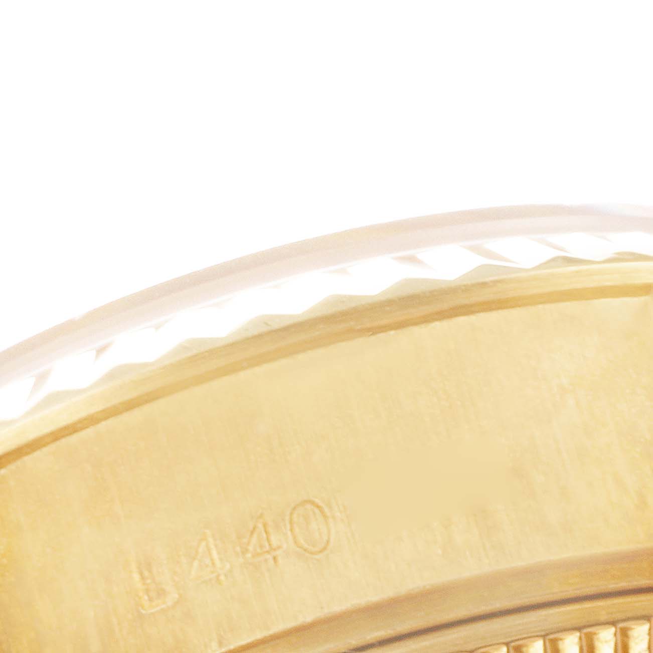 This close-up image shows the side of the bezel with partial engraving of a Rolex President 69178 Women's Yellow Gold Champagne Dial 69178 Women's Yellow Gold Champagne Dial model watch.