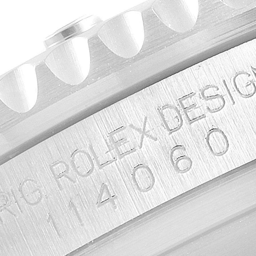 A close-up view of the side of the bezel and the engraved case side of a Rolex Submariner 114060 Men's Stainless Steel Black Dial 114060 Men's Stainless Steel Black Dial model.