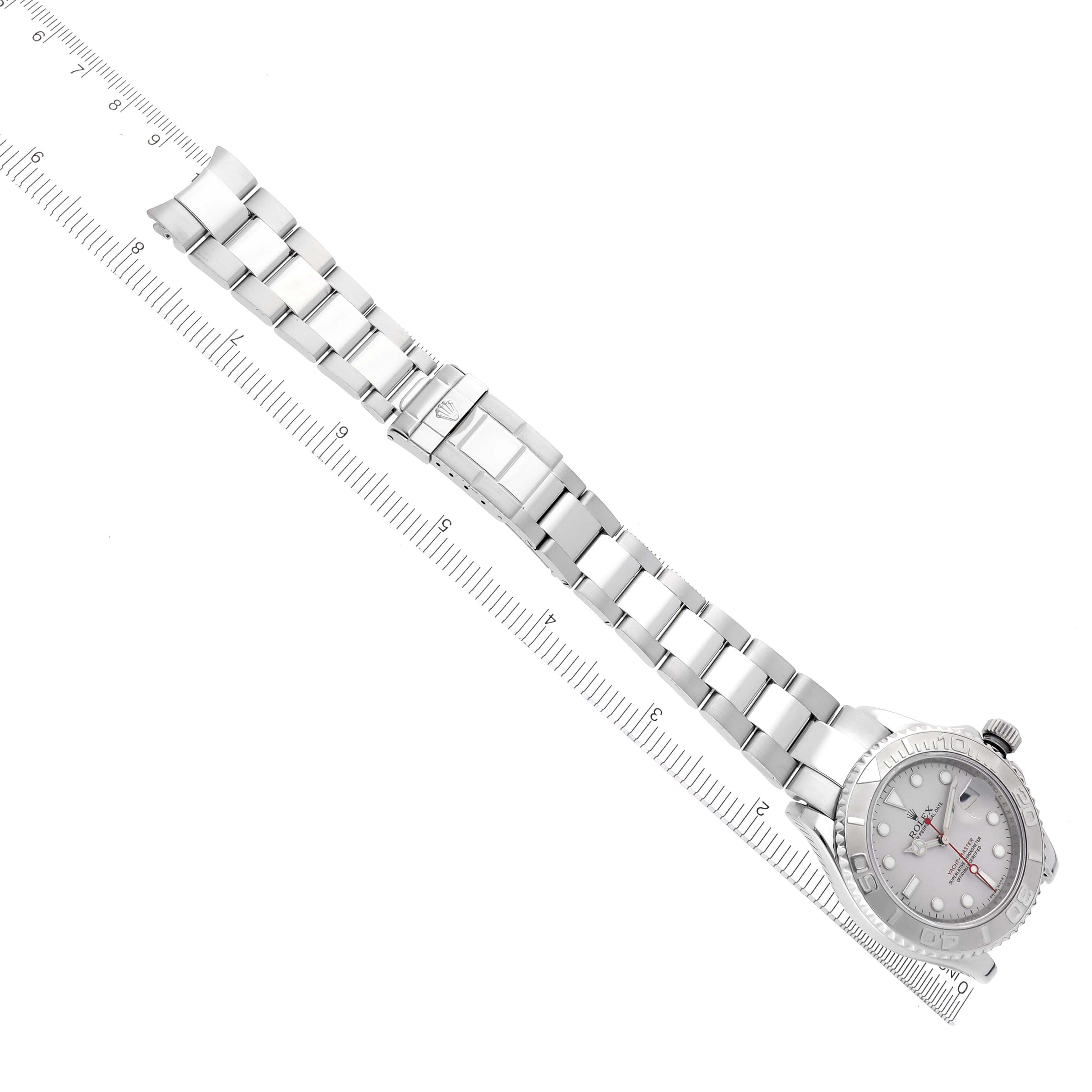 The Rolex Yacht-Master 16622 Men
s Stainless Steel Silver Dial 16622 Men
s Stainless Steel Silver Dial watch is displayed from a top angle, showing the full bracelet and dial next to a measuring scale.