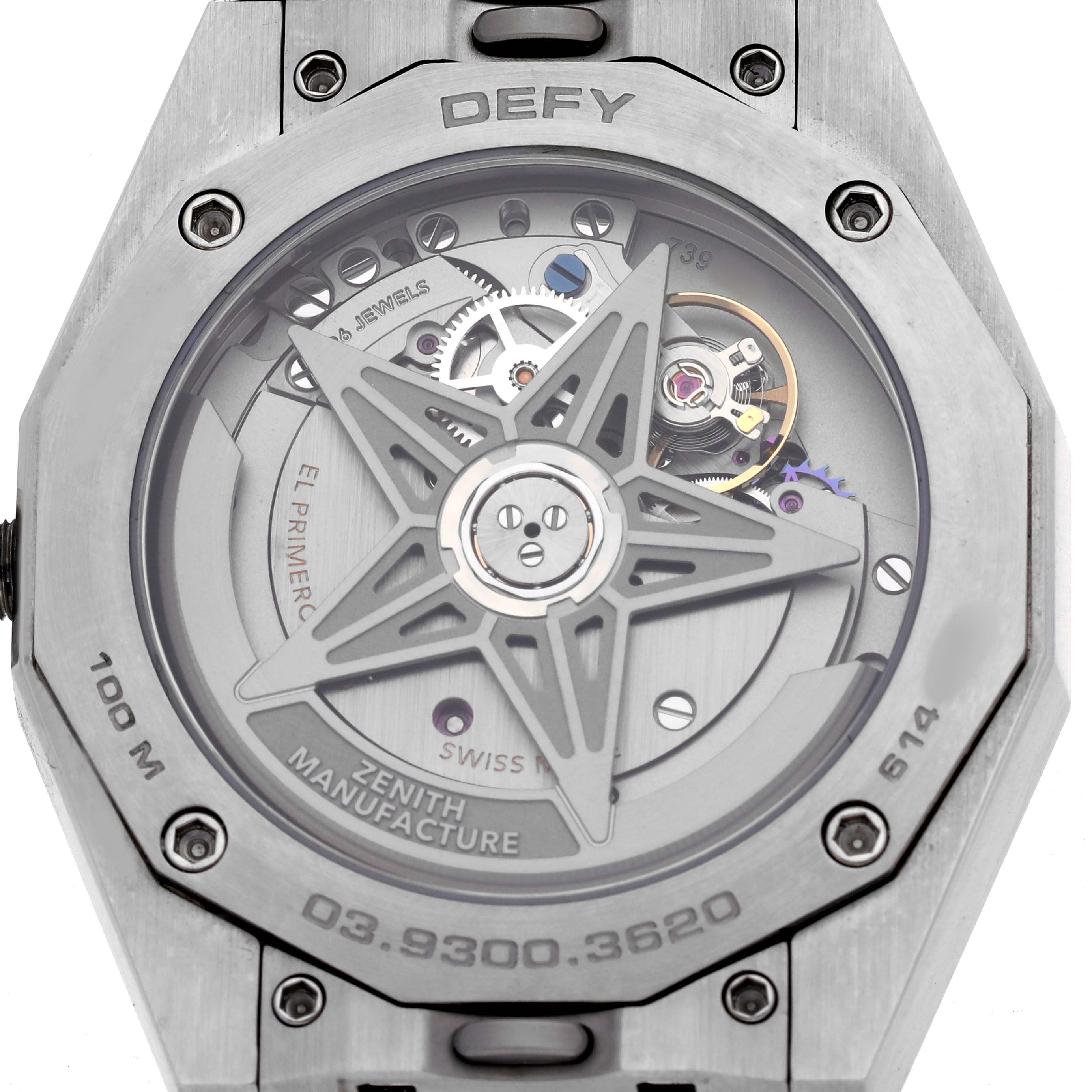 The image shows the back of a Zenith Defy 03.9300.3620 Men's Stainless Steel Black Dial watch, highlighting its movement and rotor with visible gears and branding.