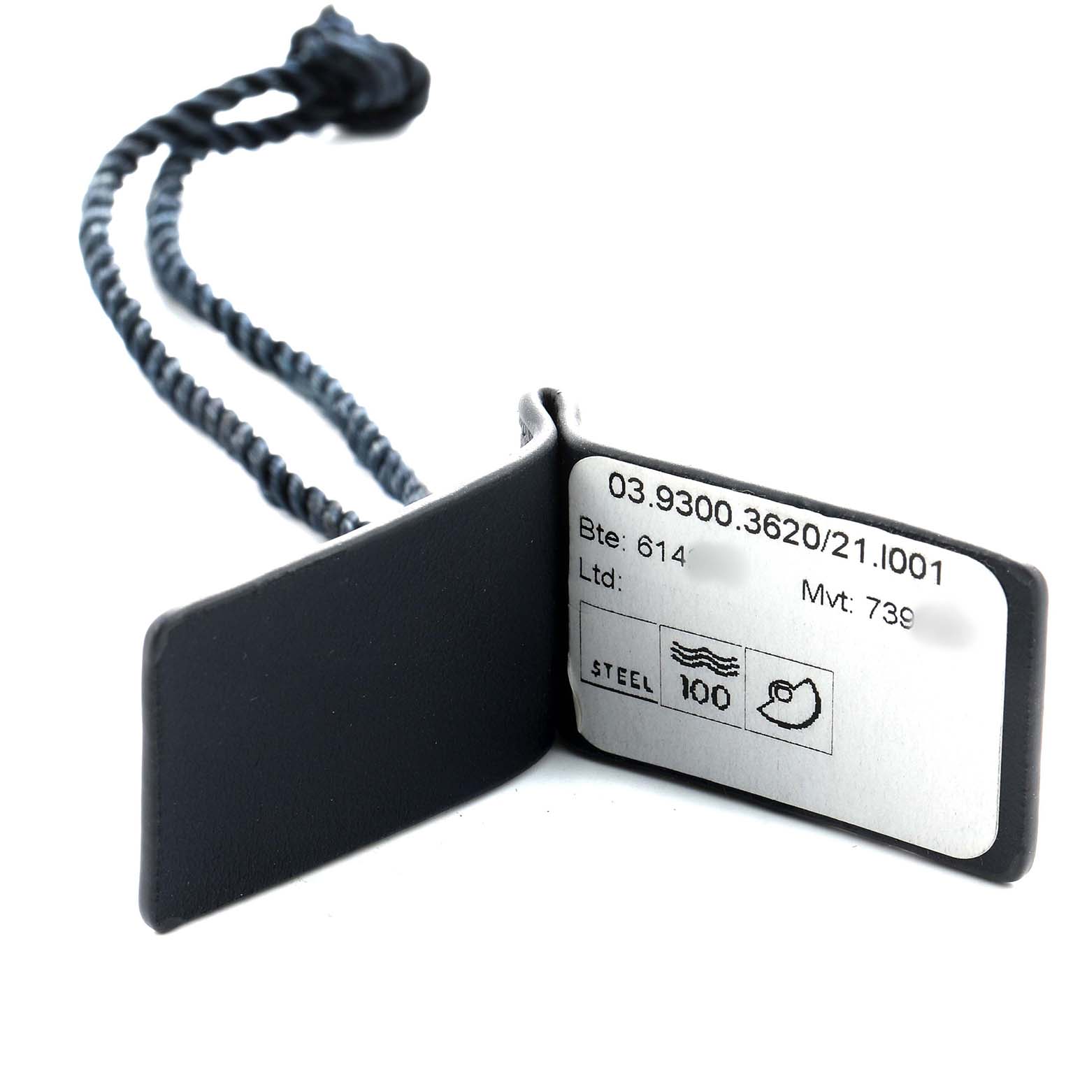 The image shows a close-up of a tag for a Zenith Defy 03.9300.3620 Men's Stainless Steel Black Dial watch, displaying model details and specifications.