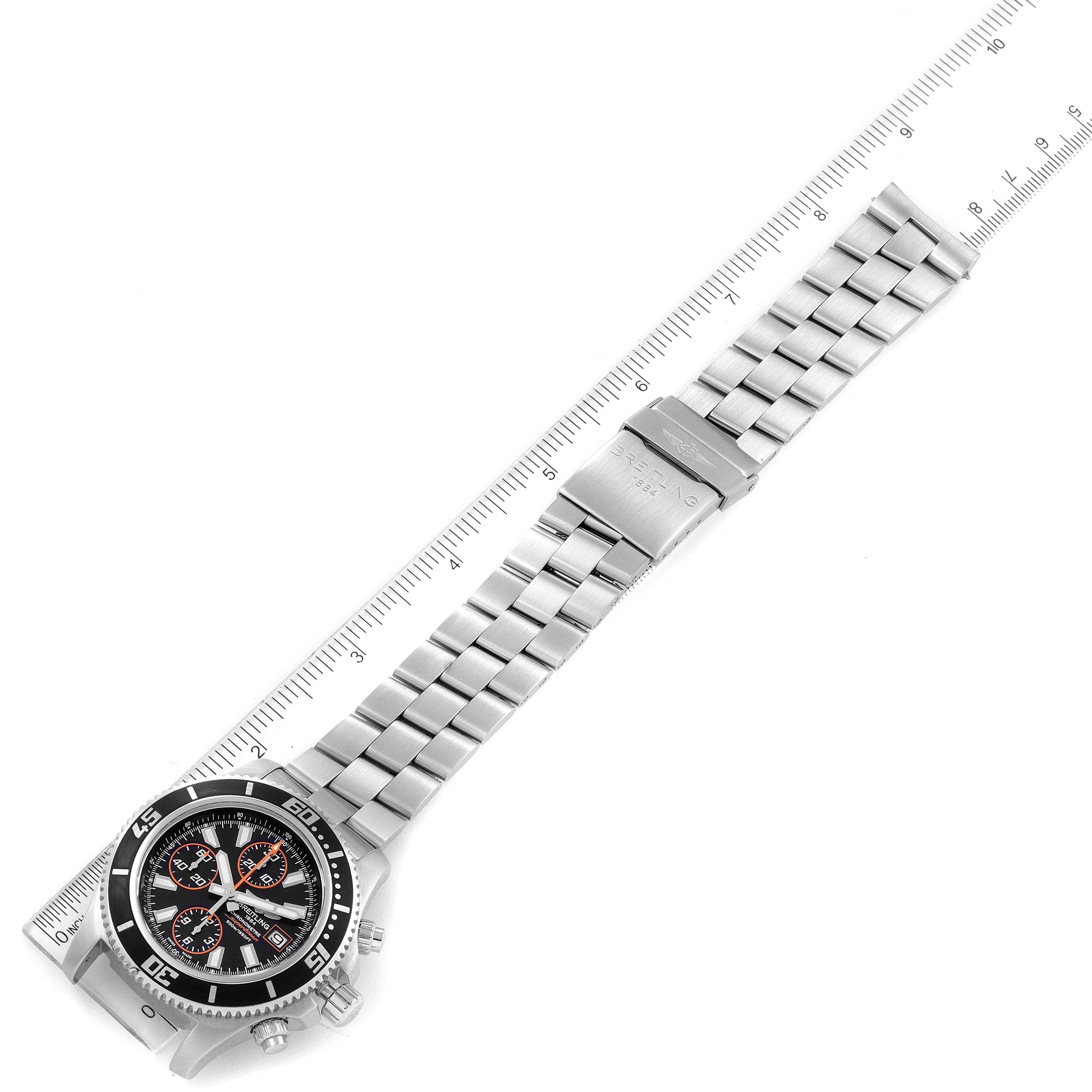 The image shows a top-down view of a Breitling Superocean A13341 Men's Stainless Steel Black Dial A13341 Men's Stainless Steel Black Dial watch with its stainless steel bracelet and clasp fully extended next to a ruler.