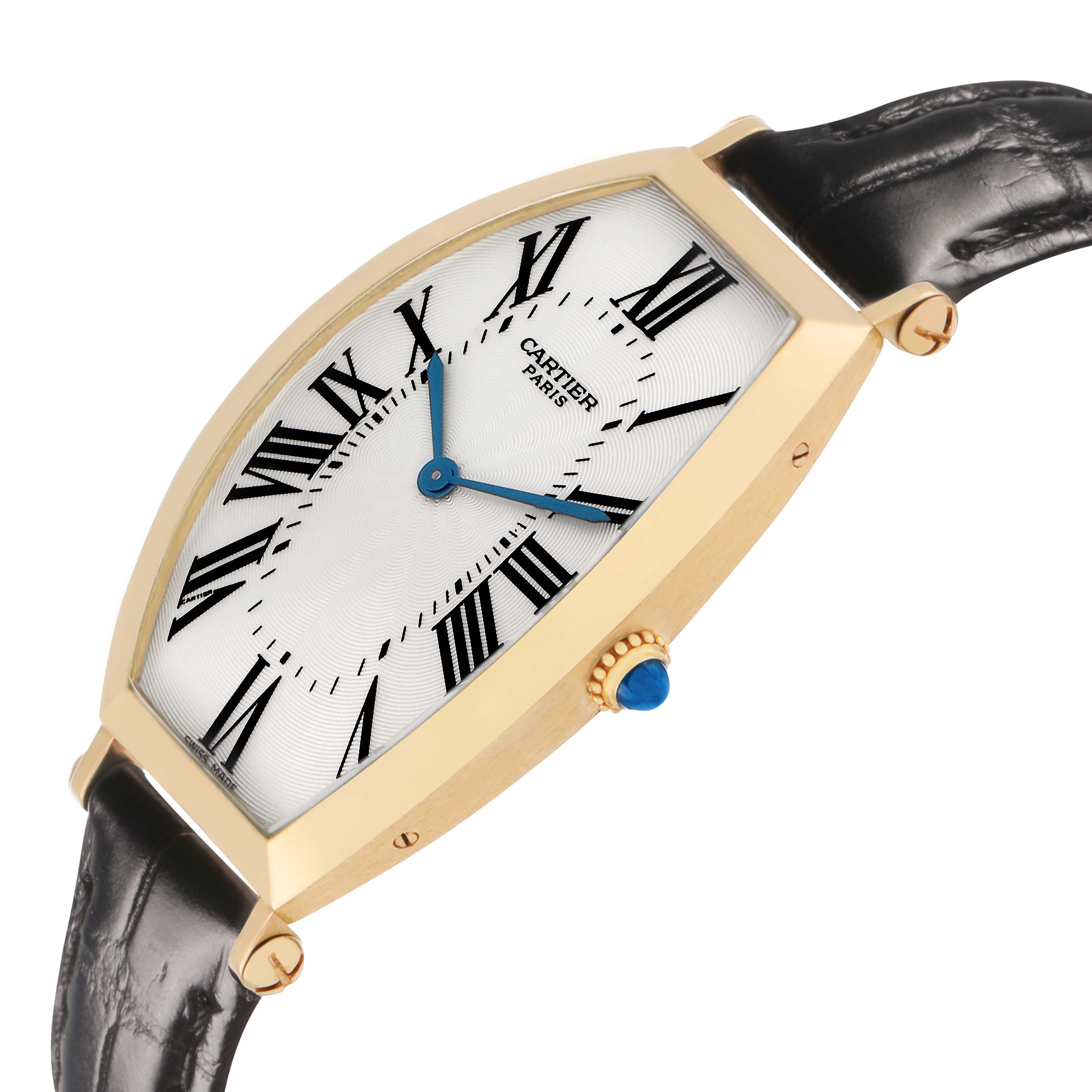 The image shows a side angle of the Cartier Tonneau W1527651F Men's Yellow Gold Silver Dial watch, highlighting its curved case, blue hands, and crown with a blue gemstone.