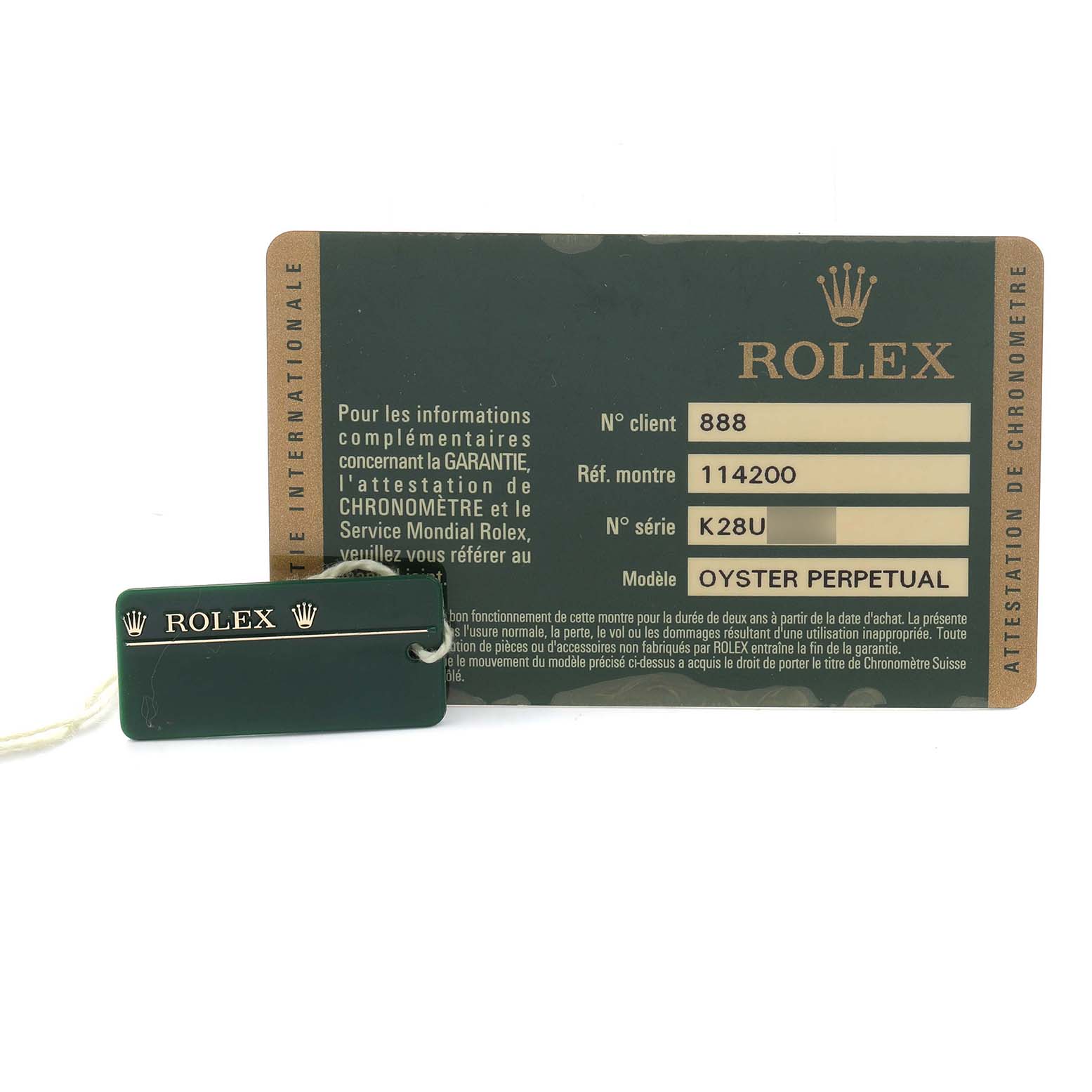 The image shows a Rolex Air-King 114200 Men's Stainless Steel White Dial warranty card and green tag with a crown logo, both laid flat.