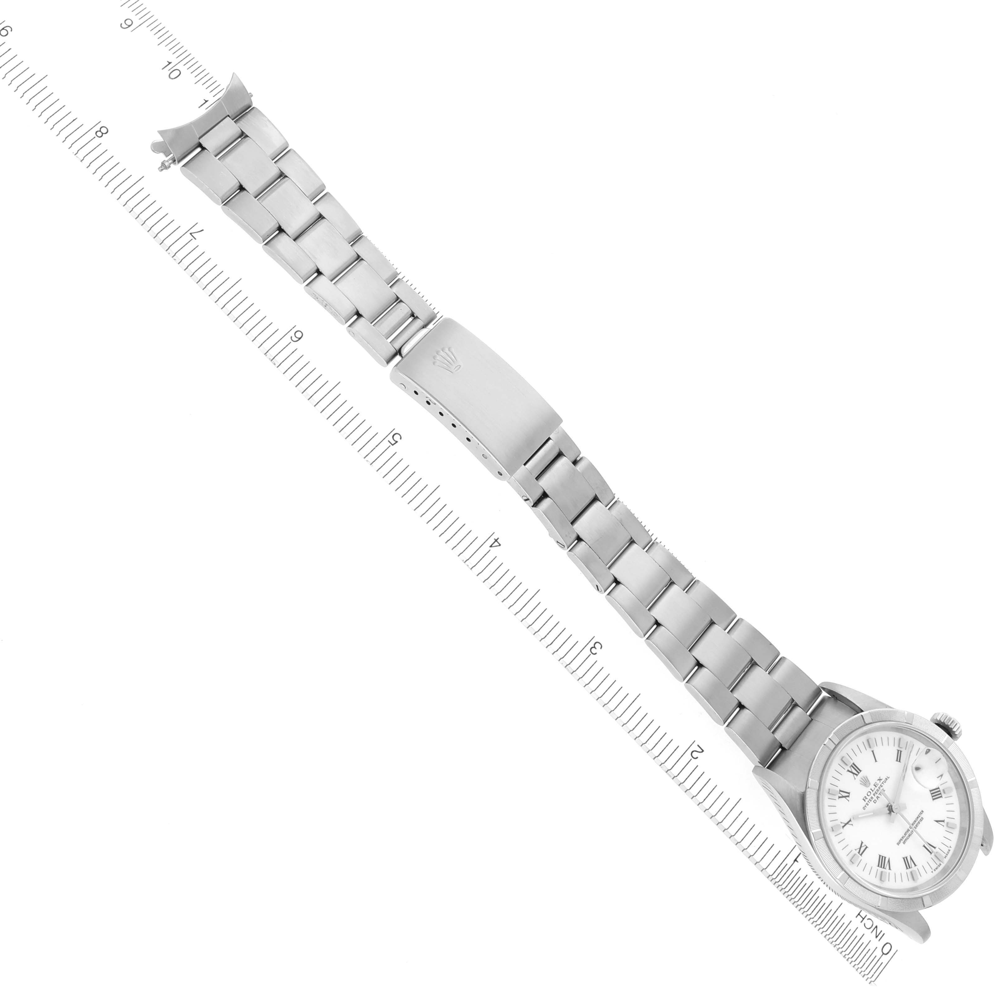 The Rolex Date 15210 Men
s Stainless Steel White Dial 15210 Men
s Stainless Steel White Dial model watch is shown from a top view, highlighting the bracelet and clasp alongside a ruler for scale.