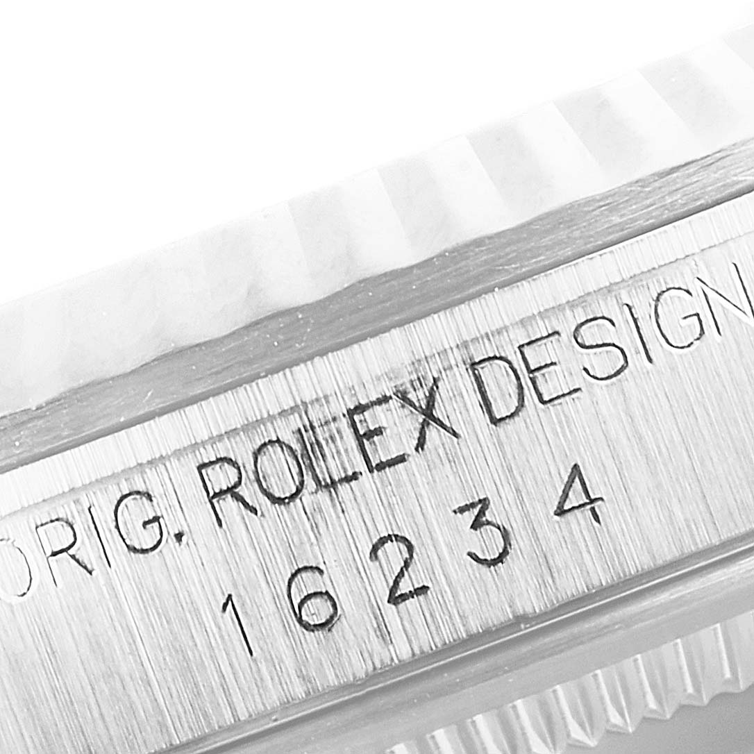 The image shows a close-up of the side of a Rolex Datejust 16234 Men's Stainless Steel Silver Dial 16234 Men's Stainless Steel Silver Dial watch, focusing on the engraved serial and model numbers.