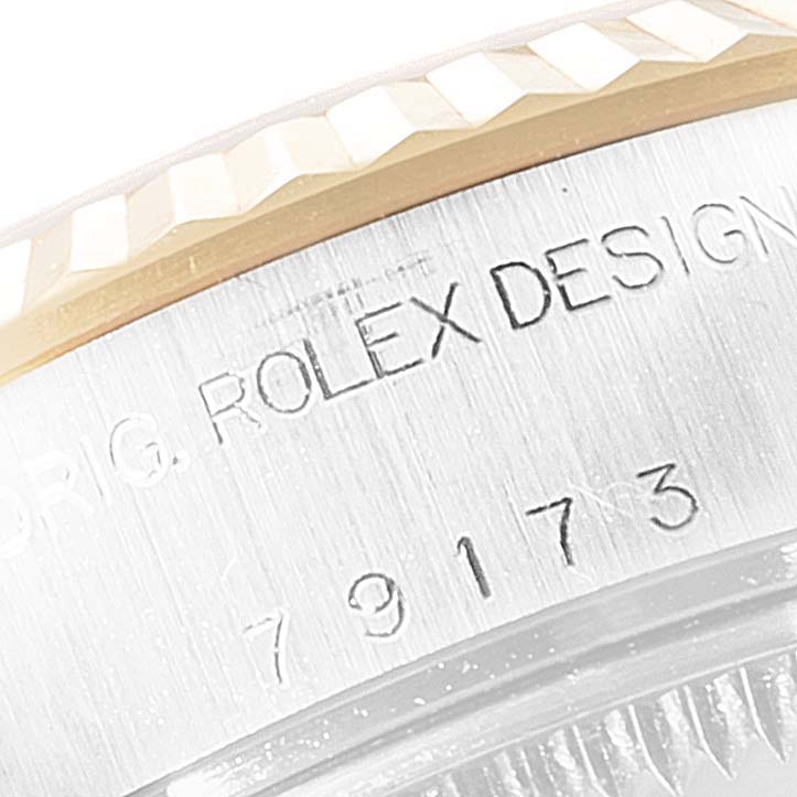 This image shows a close-up of the Rolex Datejust 69173 Women's Steel and Gold (two tone) Mother of Pearl Dial 69173 Women's Steel and Gold (two tone) Mother of Pearl Dial's engraved side with "Rolex Design" and part of the fluted bezel.