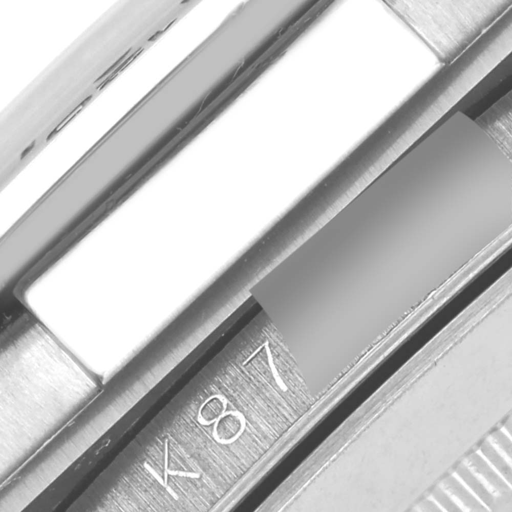 The image shows a close-up of the side bezel and part of the case of a Rolex Daytona 116519 Men's White Gold White Dial 116519 Men's White Gold White Dial watch.