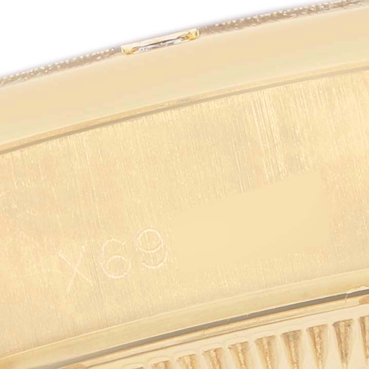 The image shows a close-up of the side and part of the bezel of a Rolex President 69288 Women's Yellow Gold Black Dial watch, highlighting its engraved details.