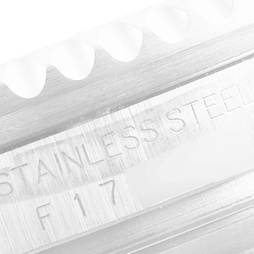 The image shows a close-up of the knurled edge and engraved markings on a stainless steel Sea-Dweller by Rolex.