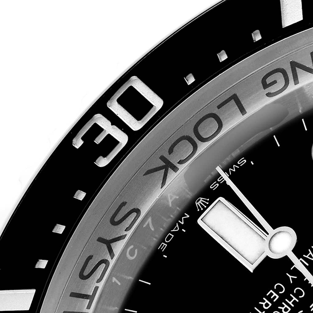 This close-up of the Rolex Sea-Dweller 136660 Men's Stainless Steel Black Dial shows part of the bezel, dial, and minute hand from an angled perspective.