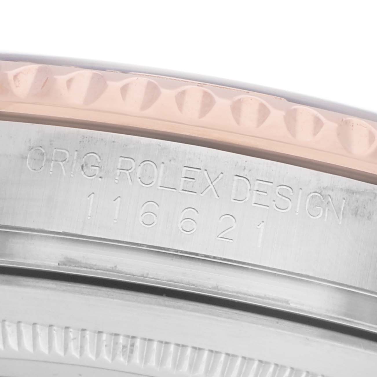 The image shows a close-up of the Rolex Yacht-Master 116621 Men's Steel and Gold (two tone) Brown Dial's bezel and engraved serial number on the side.