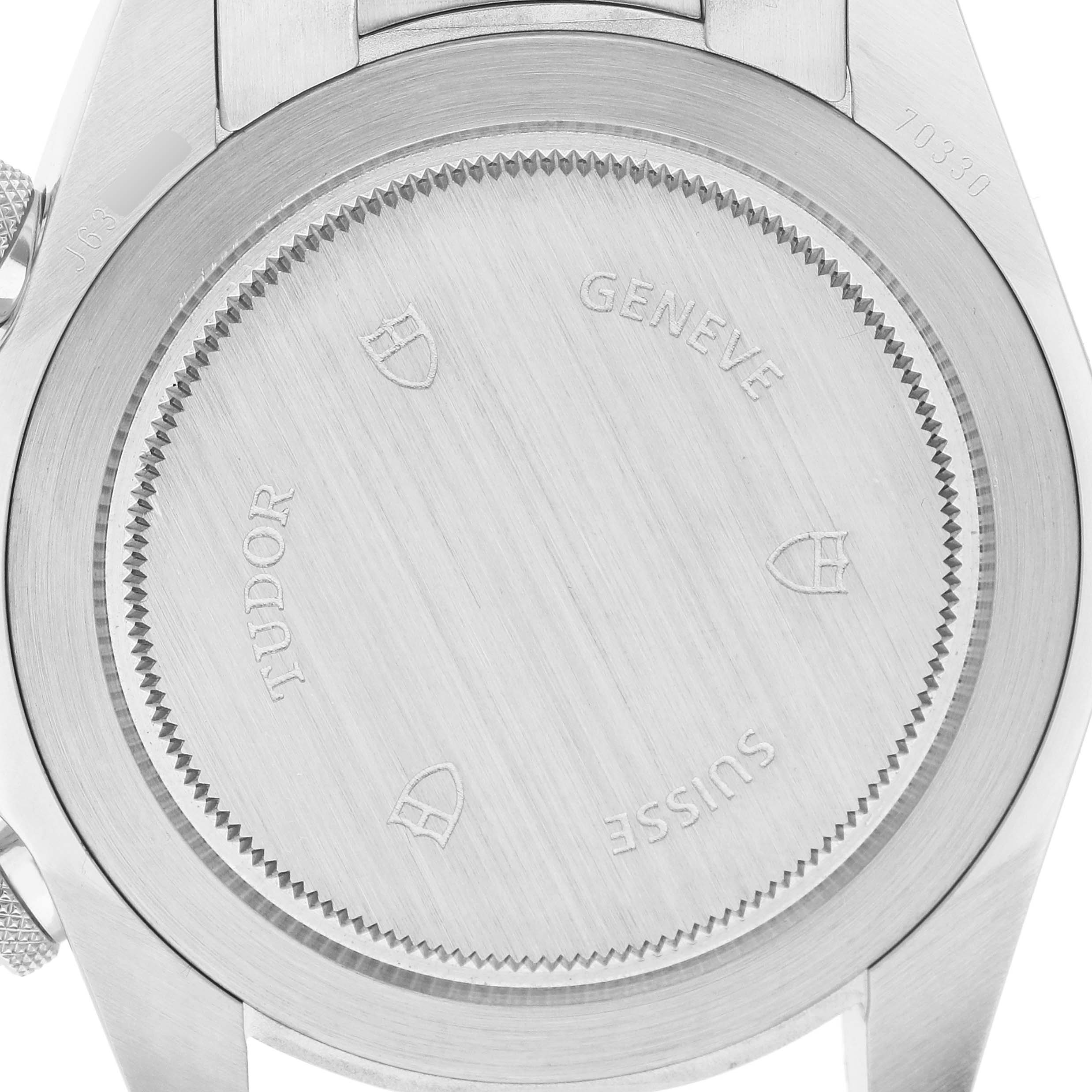 The image shows the back case of a Tudor Heritage Chrono 70330N Men's Stainless Steel Black Dial watch, highlighting brand engravings and markings.