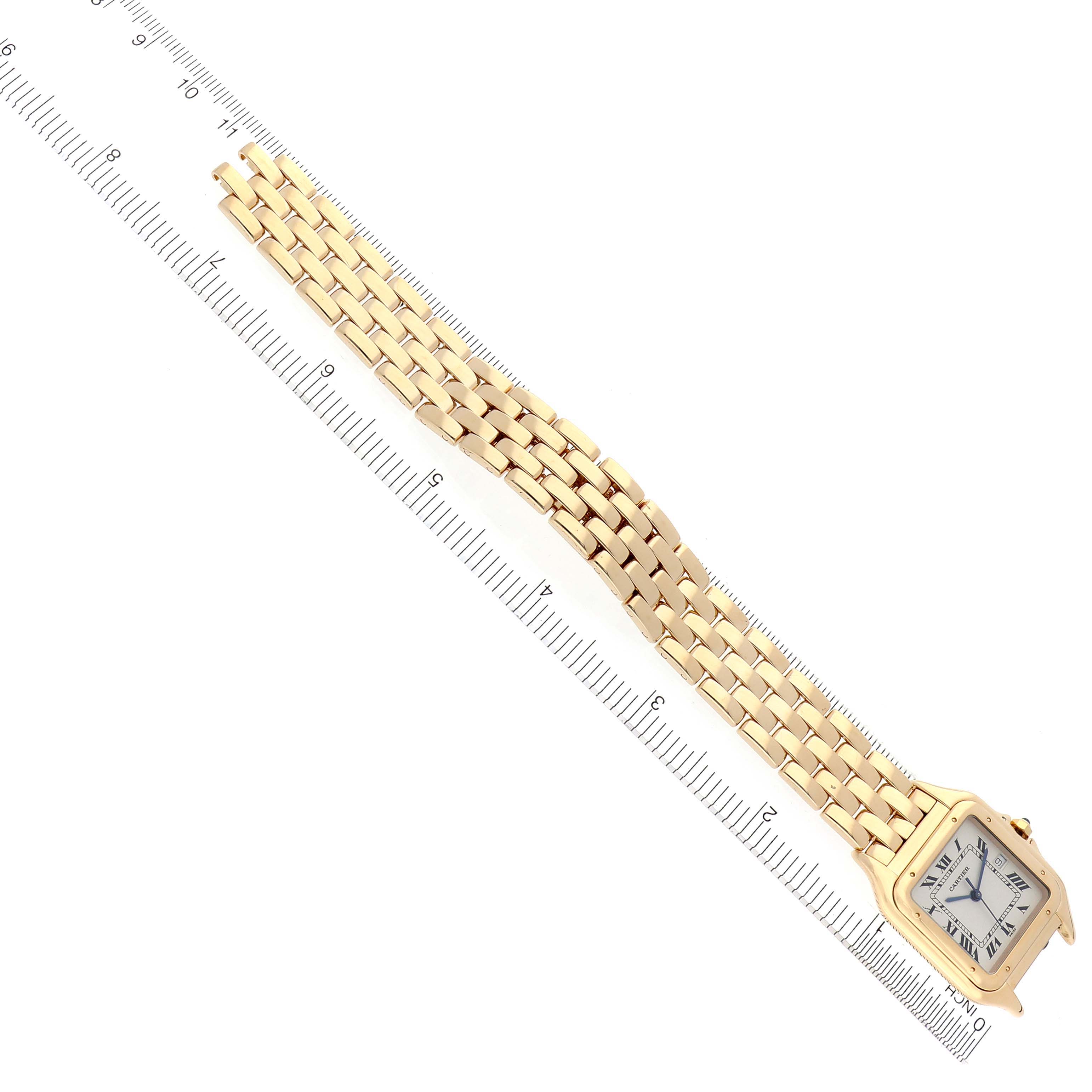The Cartier Panthere W25014B9 Men's Yellow Gold Silver Dial W25014B9 Men's Yellow Gold Silver Dial watch is shown from a top-down angle, displaying its face and bracelet next to a ruler.
