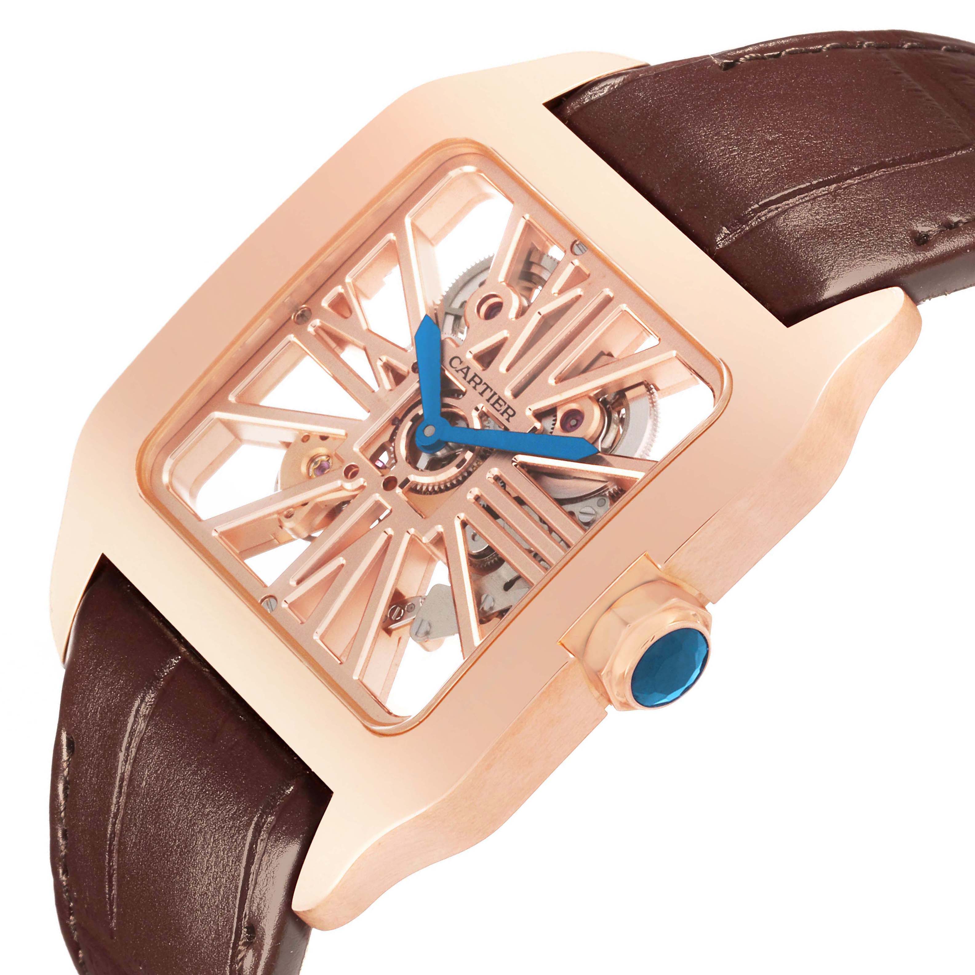 The Cartier Santos W2020057 Men's Rose Gold Transparent Dial watch is shown at an angle, highlighting its rose gold case, blue hands, openwork dial, and brown leather strap.