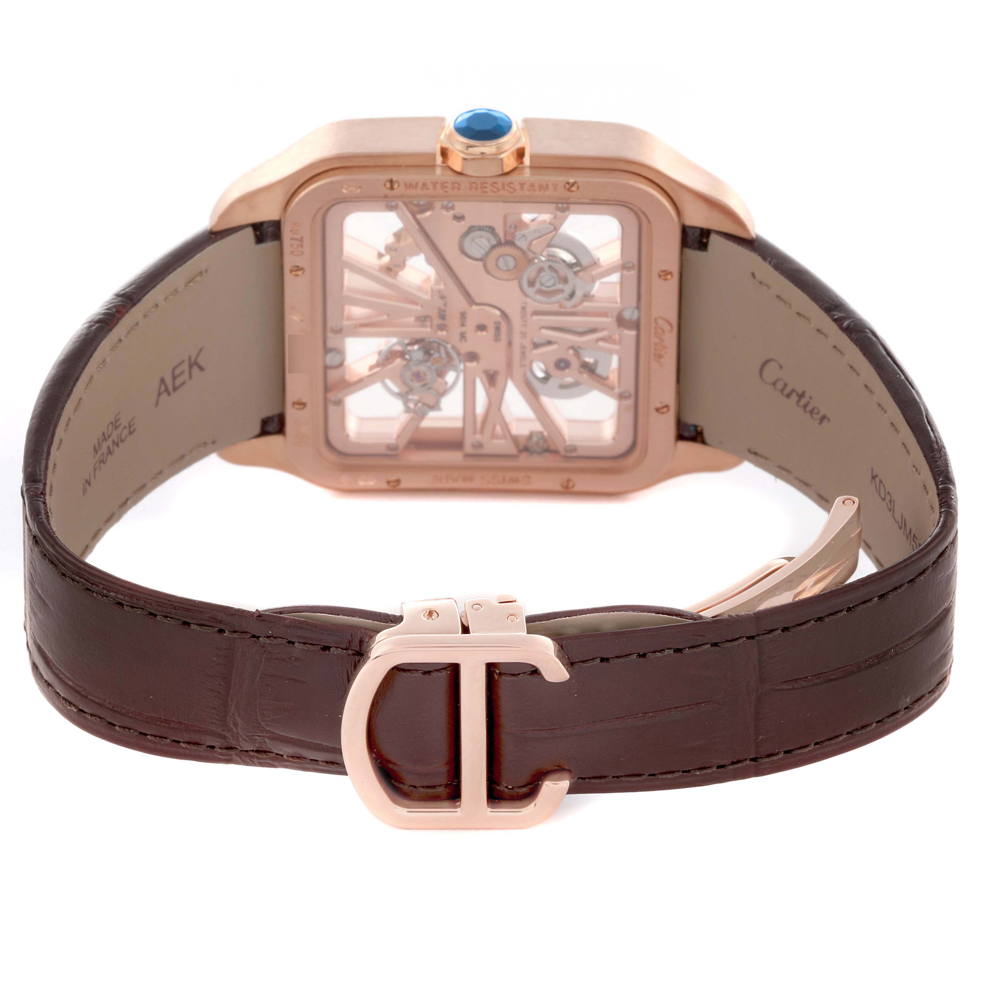 The Santos by Cartier watch is shown from the back, highlighting its rose gold case and brown leather strap with a clasp.