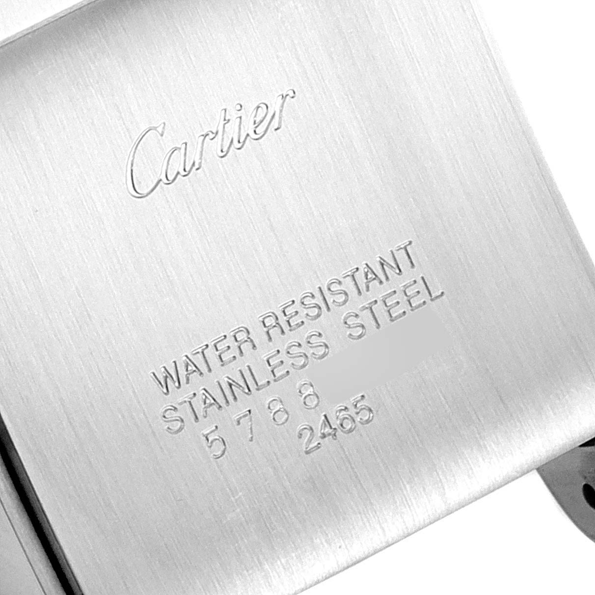 This image shows the back case of a Tank Française model by Cartier, highlighting the engravings with the brand name and material details.