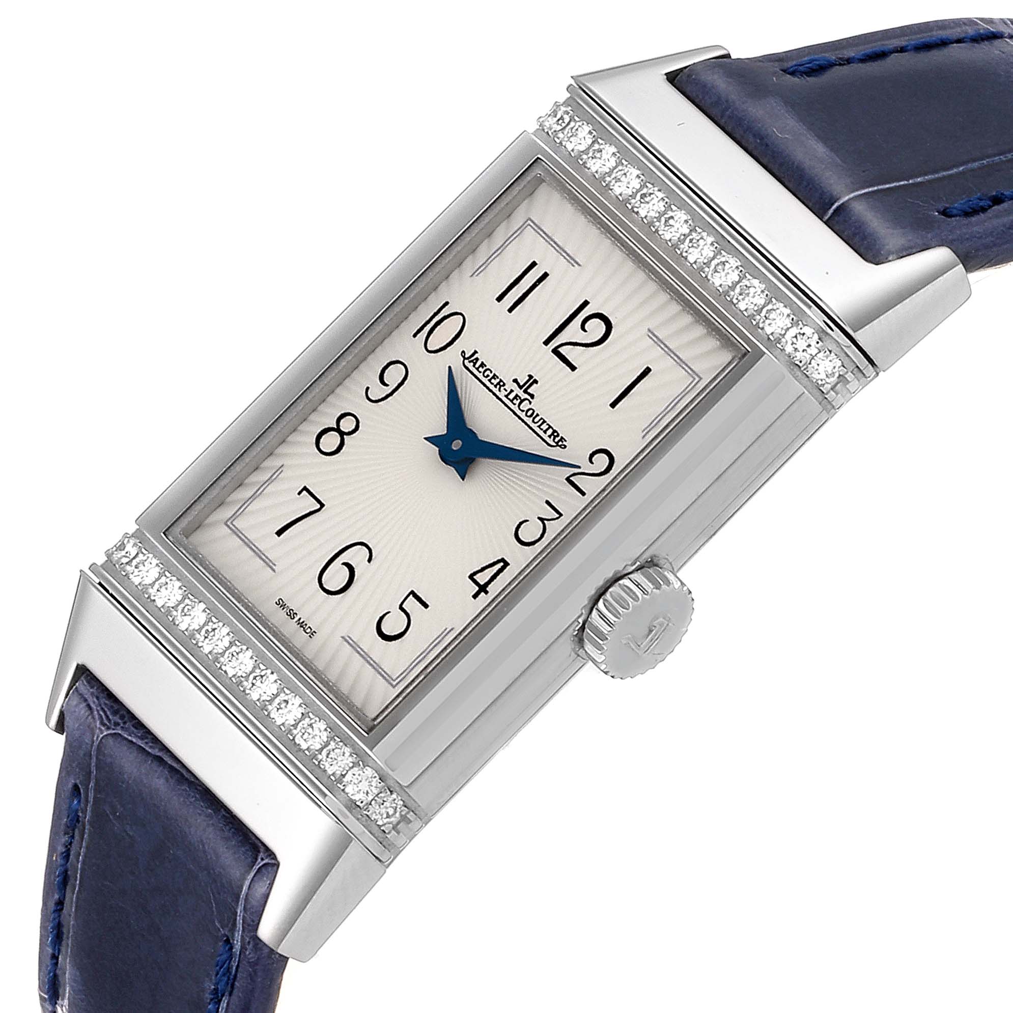 The Jaeger-LeCoultre Reverso watch is shown at a slightly tilted angle, highlighting its face, crown, strap, and diamond accents.