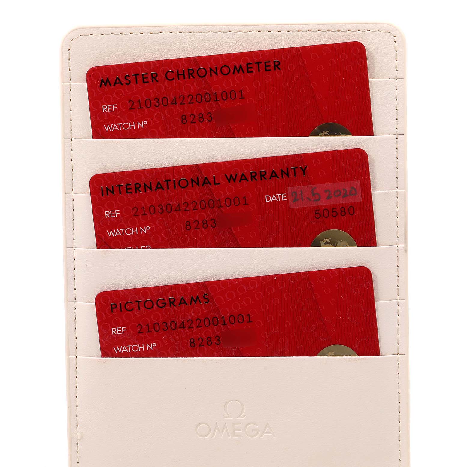The image shows three official red cards for a Seamaster Omega watch: Master Chronometer, International Warranty, and Pictograms.