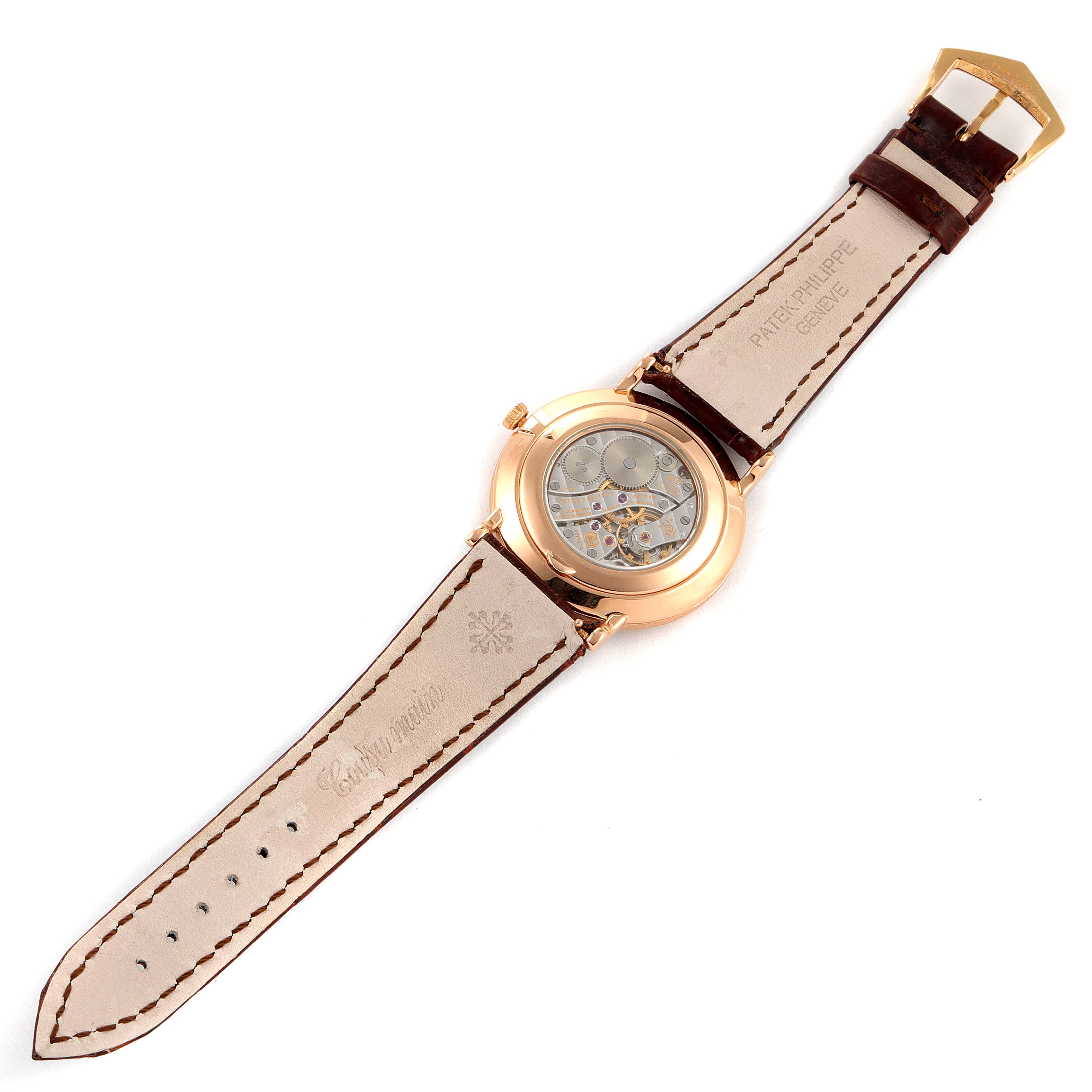 The image shows the back and inner mechanism of a Patek Philippe Calatrava 5119R Men's Rose Gold White Dial 5119R Men's Rose Gold White Dial watch, with the leather strap fully extended.