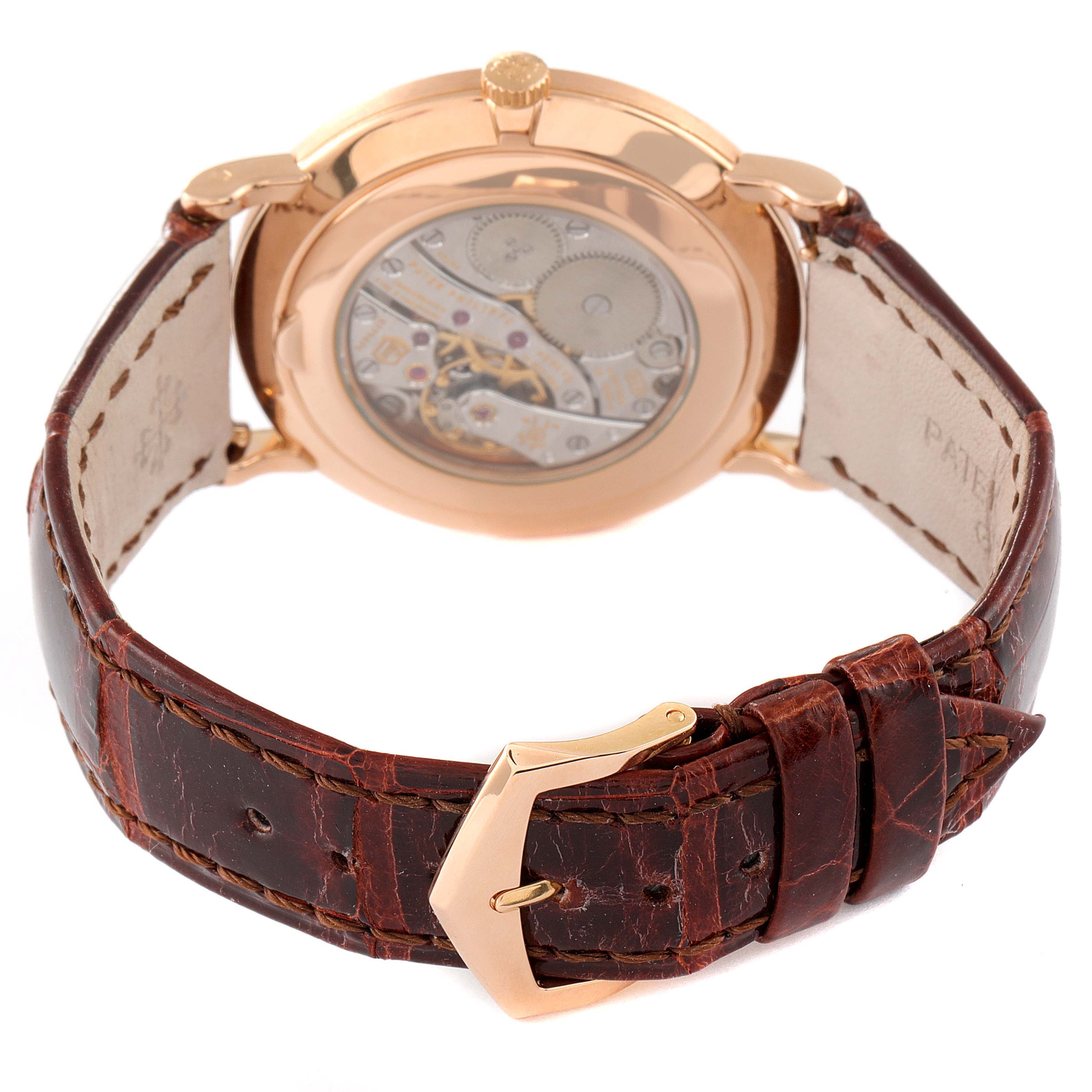 The image shows the back view of a Patek Philippe Calatrava 5119R Men's Rose Gold White Dial 5119R Men's Rose Gold White Dial watch, highlighting its movement and leather strap with gold buckle.