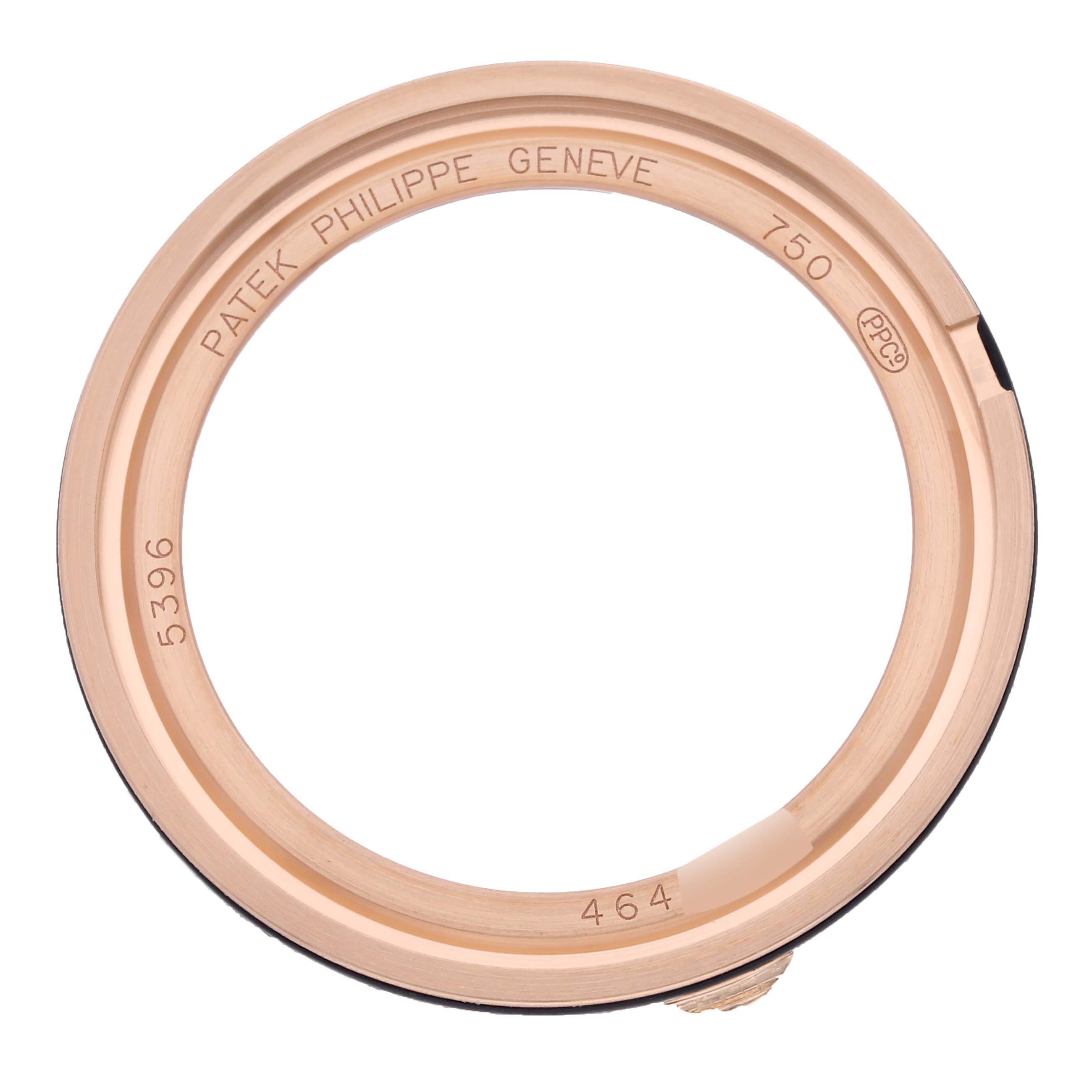 This image shows a Patek Philippe Complications 5396R-011 Men
s Rose Gold Silver Dial 5396R-011 Men
s Rose Gold Silver Dial watch bezel from a top-down angle featuring engraved details.