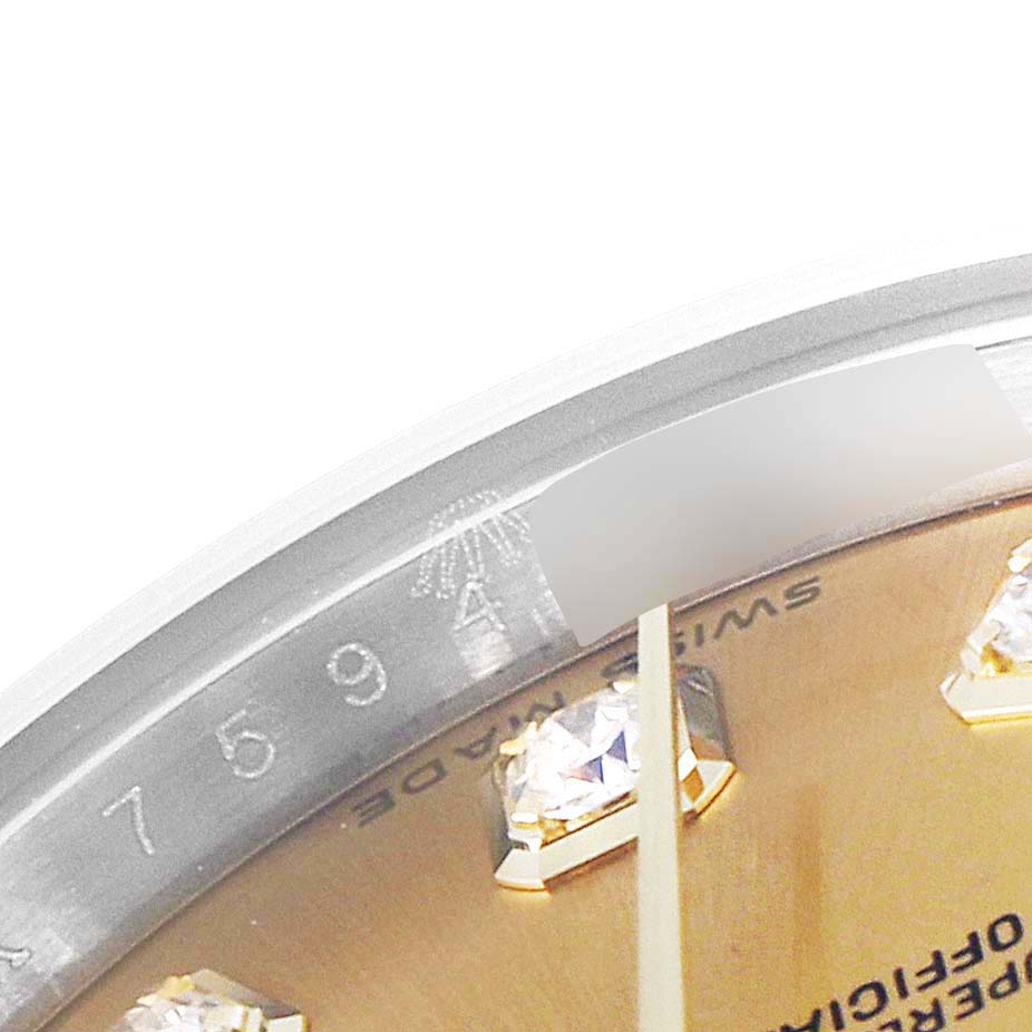 This close-up image of the Rolex Datejust 179173 Women
s Steel and Gold (two tone) Champagne Dial 179173 Women
s Steel and Gold (two tone) Champagne Dial watch shows part of the dial with diamond markers and a portion of the rehaut with engraved numbers.