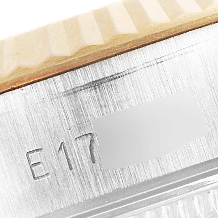 This close-up image shows a portion of the case and bezel of a Rolex Datejust 69173 Women
s Steel and Gold (two tone) Champagne Dial 69173 Women
s Steel and Gold (two tone) Champagne Dial watch, highlighting the serial number engraving.