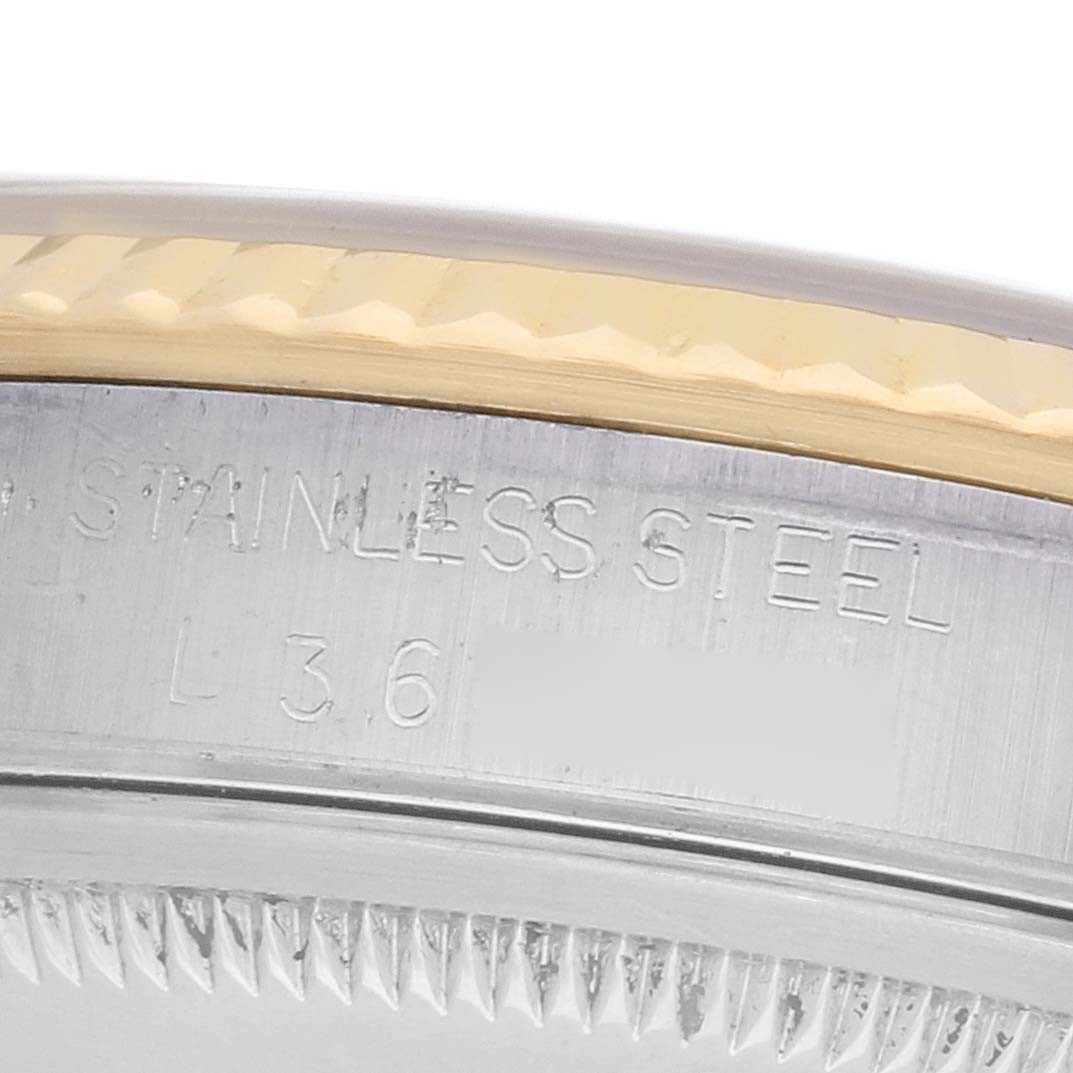 The image shows a close-up of the bezel and edge of a Rolex Datejust 16233 Men's Steel and Gold (two tone) Champagne Dial, highlighting "stainless steel" text and a fluted design.