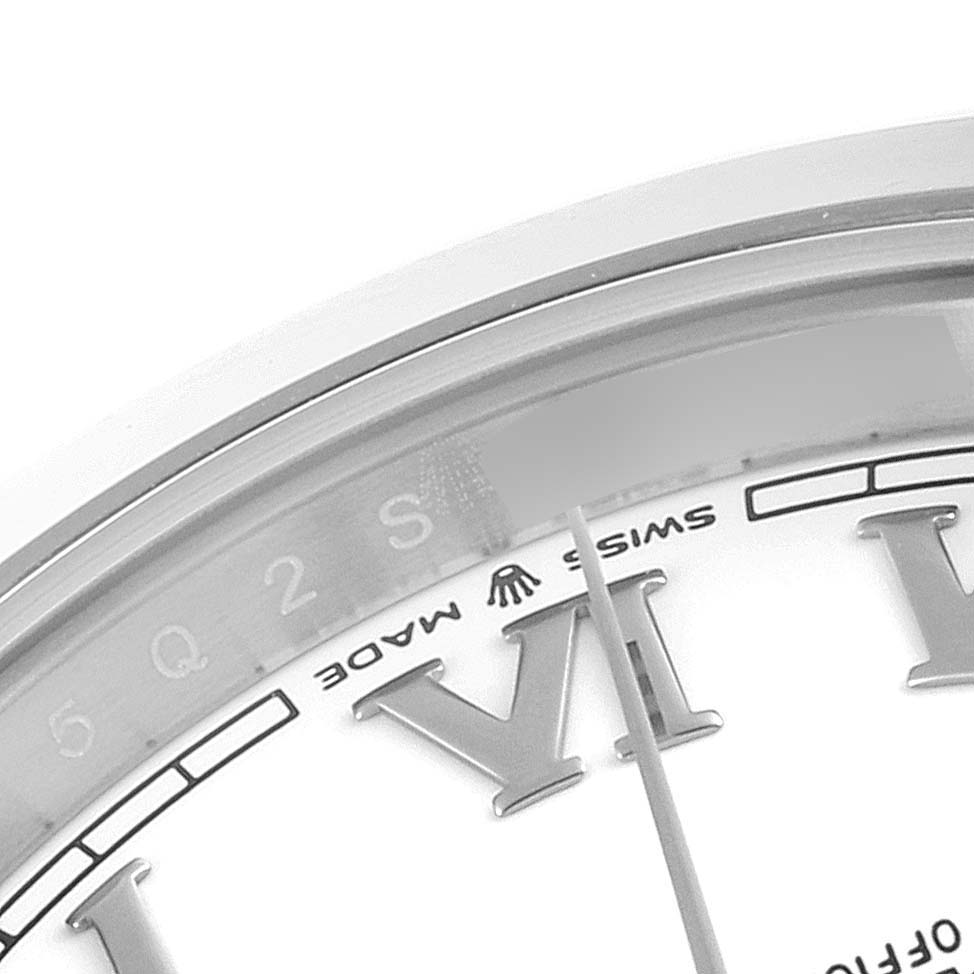 This close-up image of the Rolex Datejust 41 126300 Men
s Stainless Steel White Dial 126300 Men
s Stainless Steel White Dial watch shows part of the dial, a section of the bezel, and the minute hand.