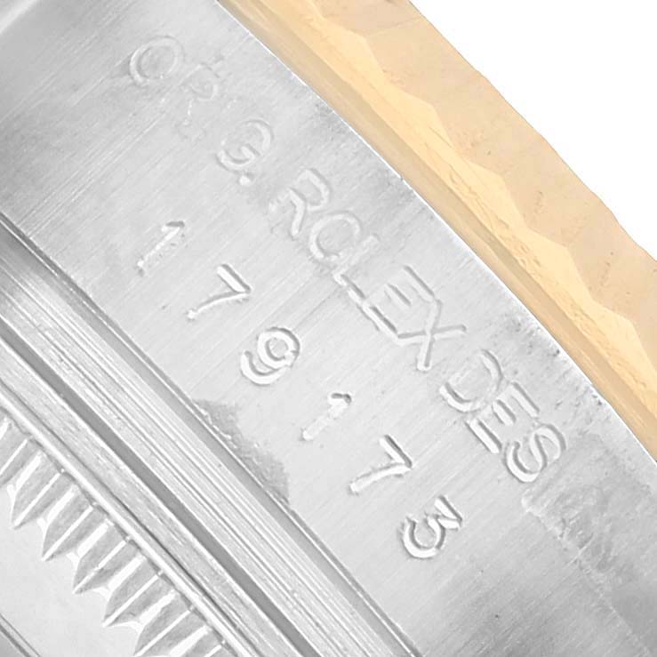 The image shows an angled close-up of the Rolex Datejust 179173 Women's Steel and Gold (two tone) Champagne Dial's fluted bezel and engraved edge on the case side.