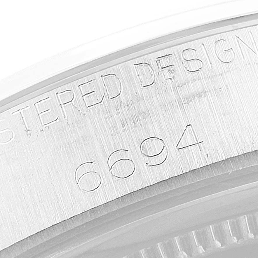 This close-up image shows the engraved model number and "REGISTERED DESIGN" text on the case side of the Rolex Vintage Collection 6694 Men's Stainless Steel Silver Dial 6694 Men's Stainless Steel Silver Dial watch.
