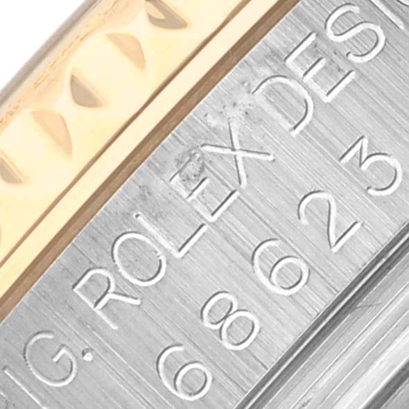 The image shows a close-up of the engraved side of a Rolex Yacht-Master 68623 Men's Steel and Gold (two tone) Blue Dial 68623 Men's Steel and Gold (two tone) Blue Dial watch bezel and case.