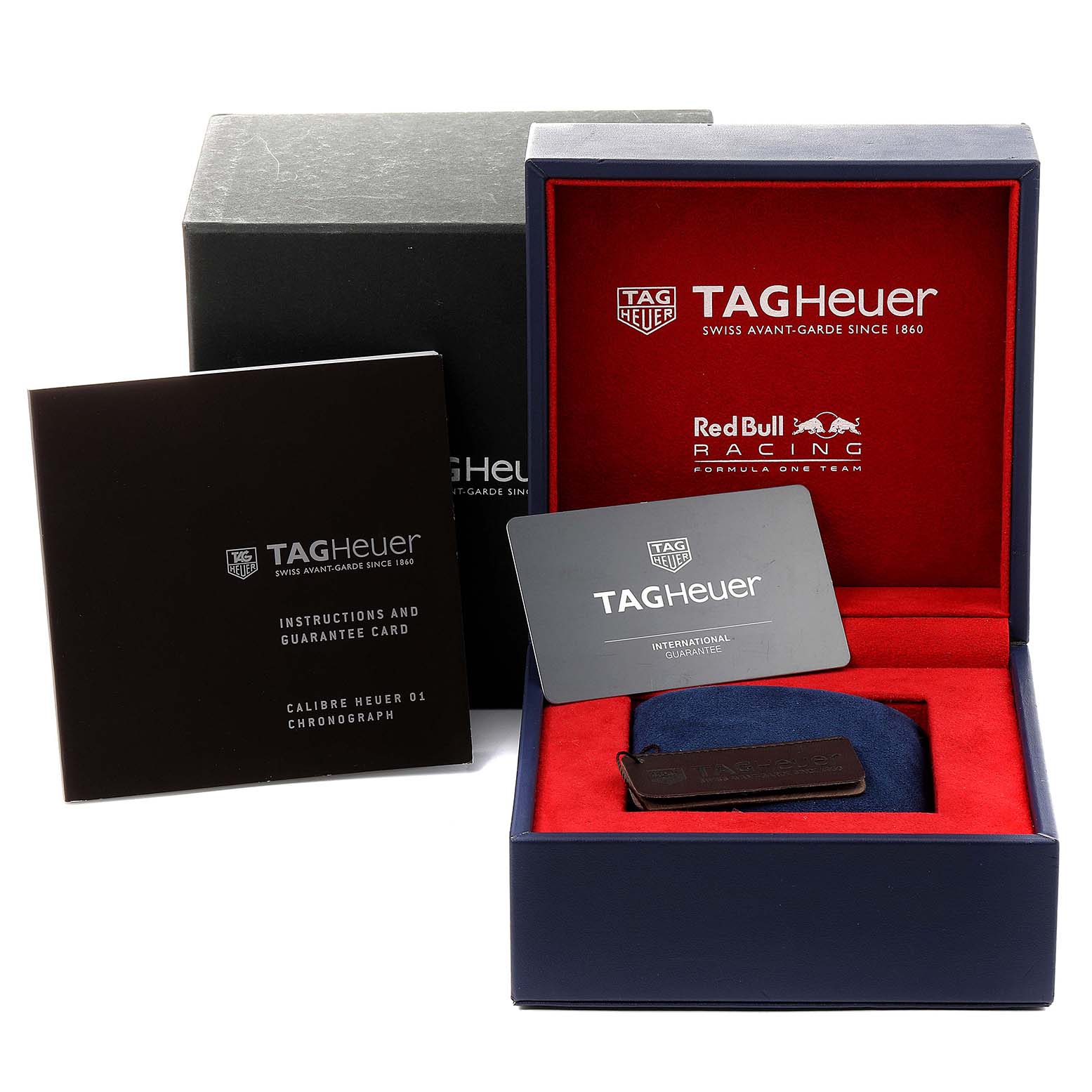 The image shows a Tag Heuer Carrera CAR2A1K.BA0703 Men
s Stainless Steel Blue Dial CAR2A1K.BA0703 Men
s Stainless Steel Blue Dial watch box, instruction manual, and guarantee card from a front angle.