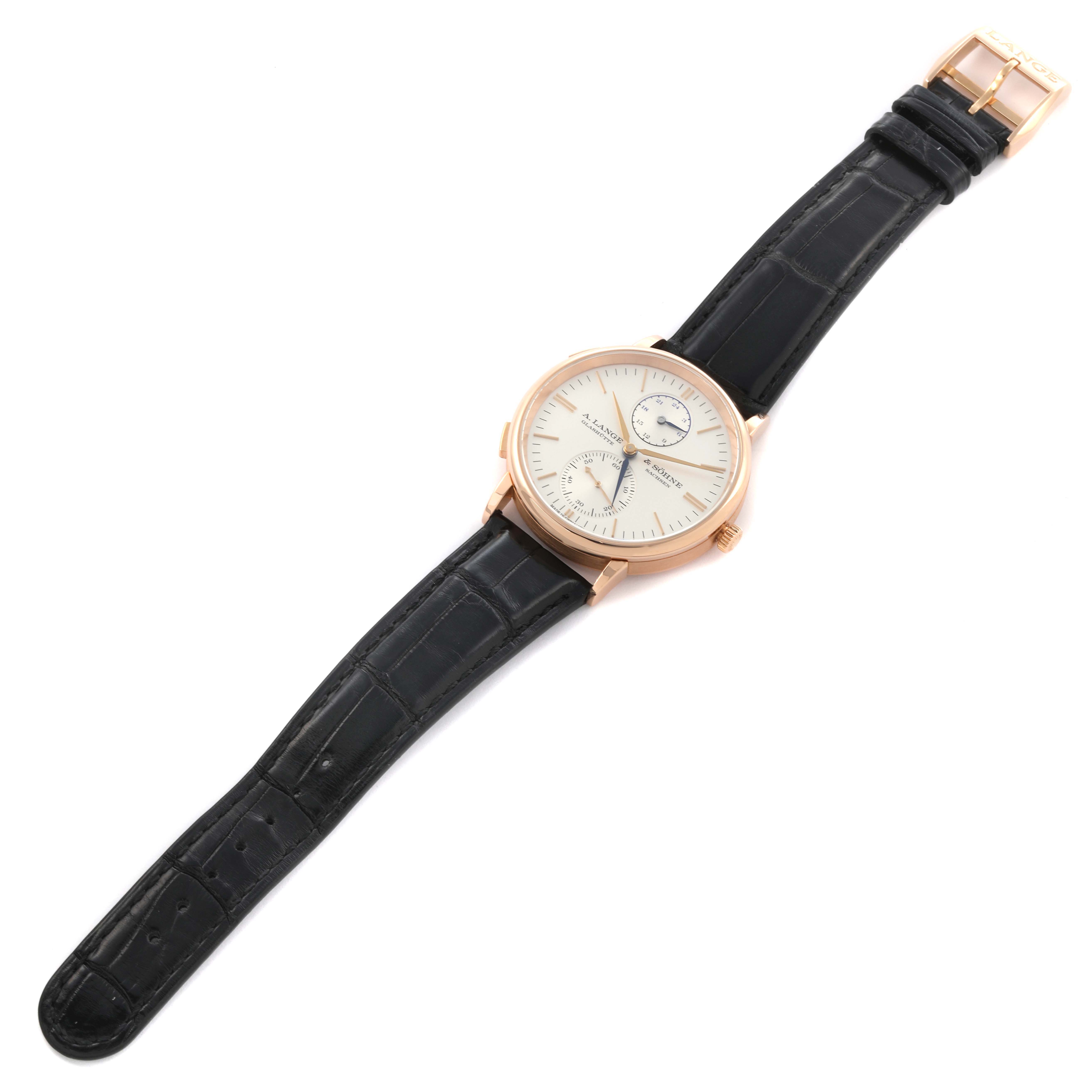 The A. Lange & Sohne Saxonia 386.032 Men's Rose Gold Silver Dial watch is shown from a top angle, displaying the face, case, and leather strap.