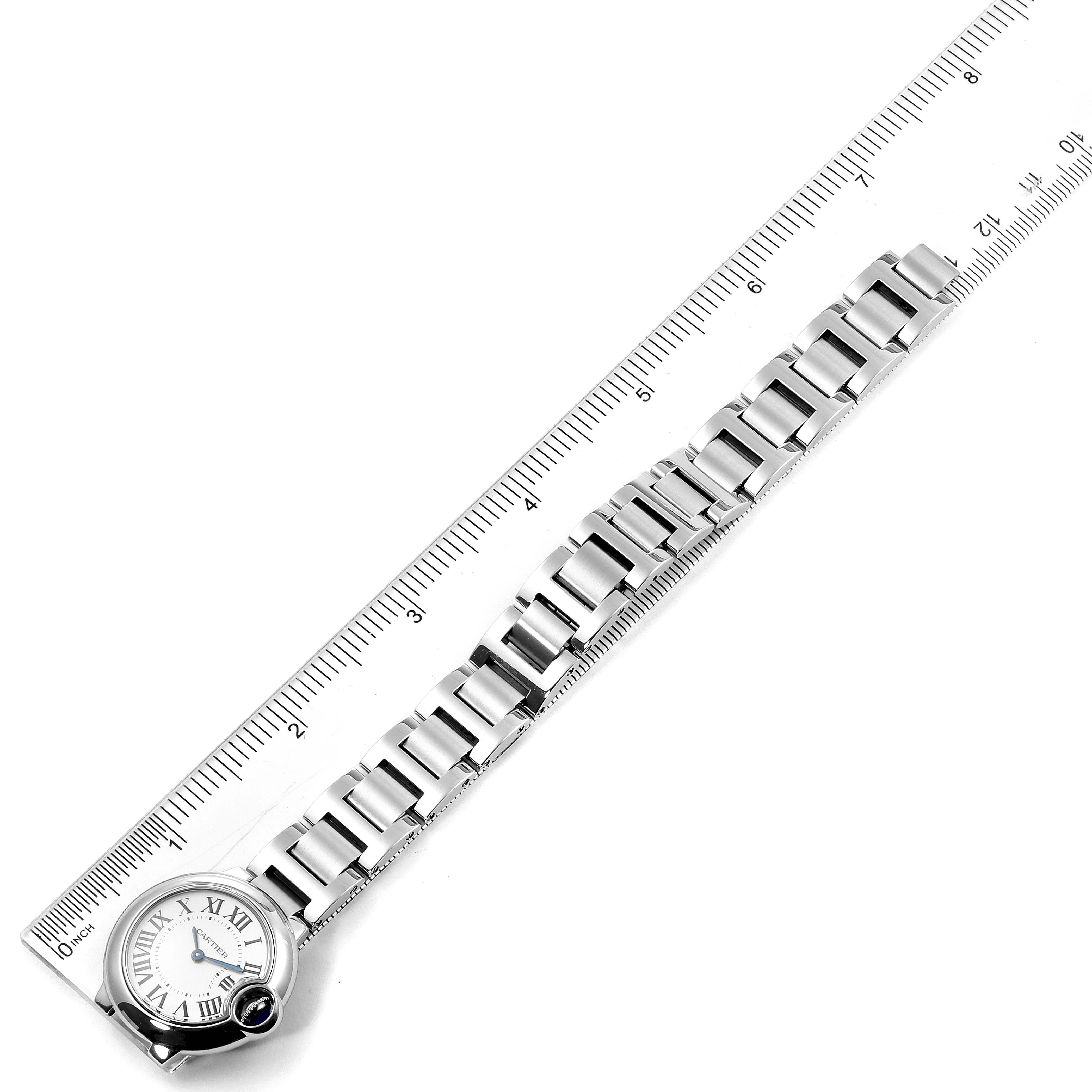 This Ballon Bleu model by Cartier is shown at a top-down angle, highlighting its face and stainless steel bracelet alongside a ruler.