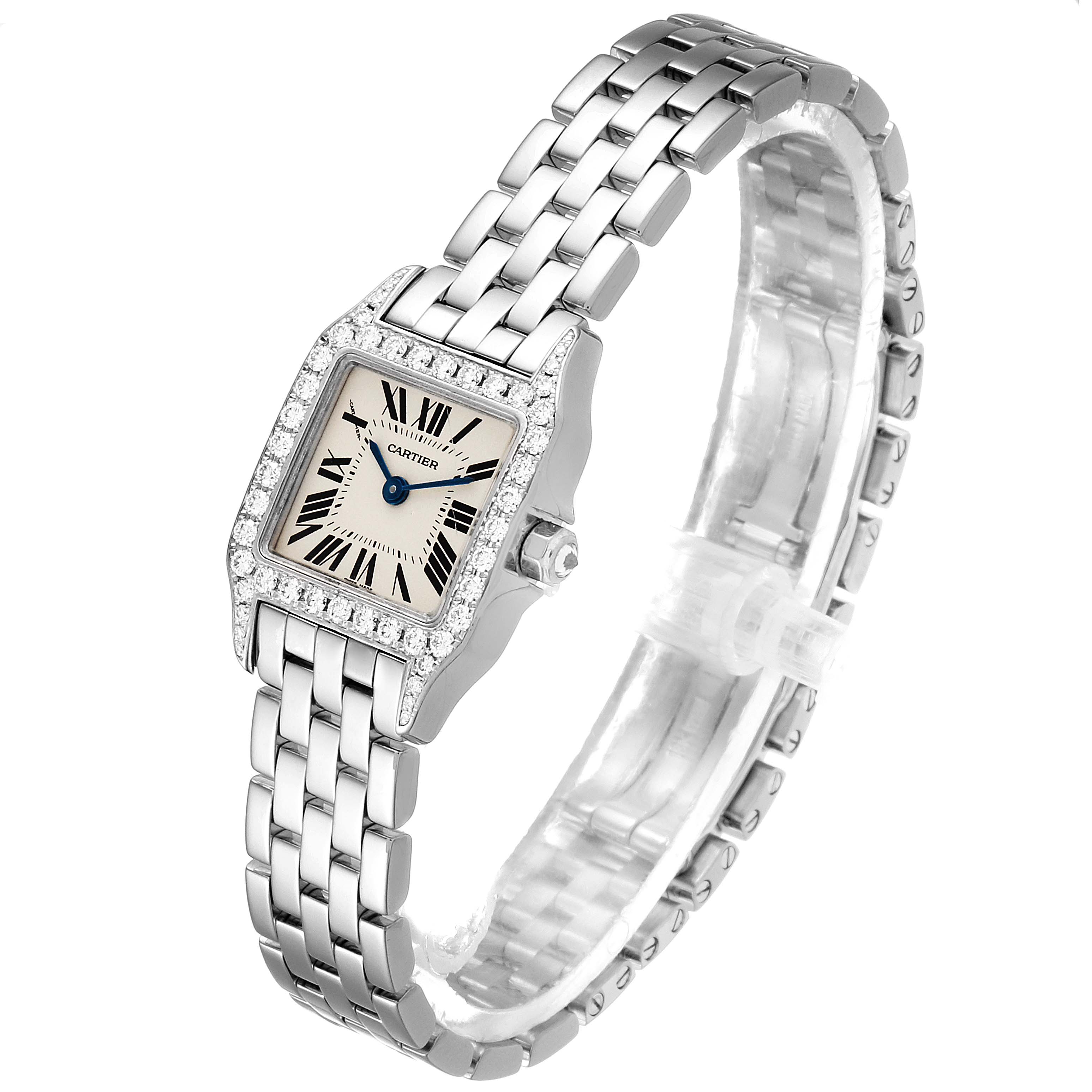 The image shows a Cartier Santos Demoiselle WF9005Y8 Women's White Gold Silver Dial WF9005Y8 Women's White Gold Silver Dial watch from an angled perspective, highlighting its face, bezel, and bracelet.