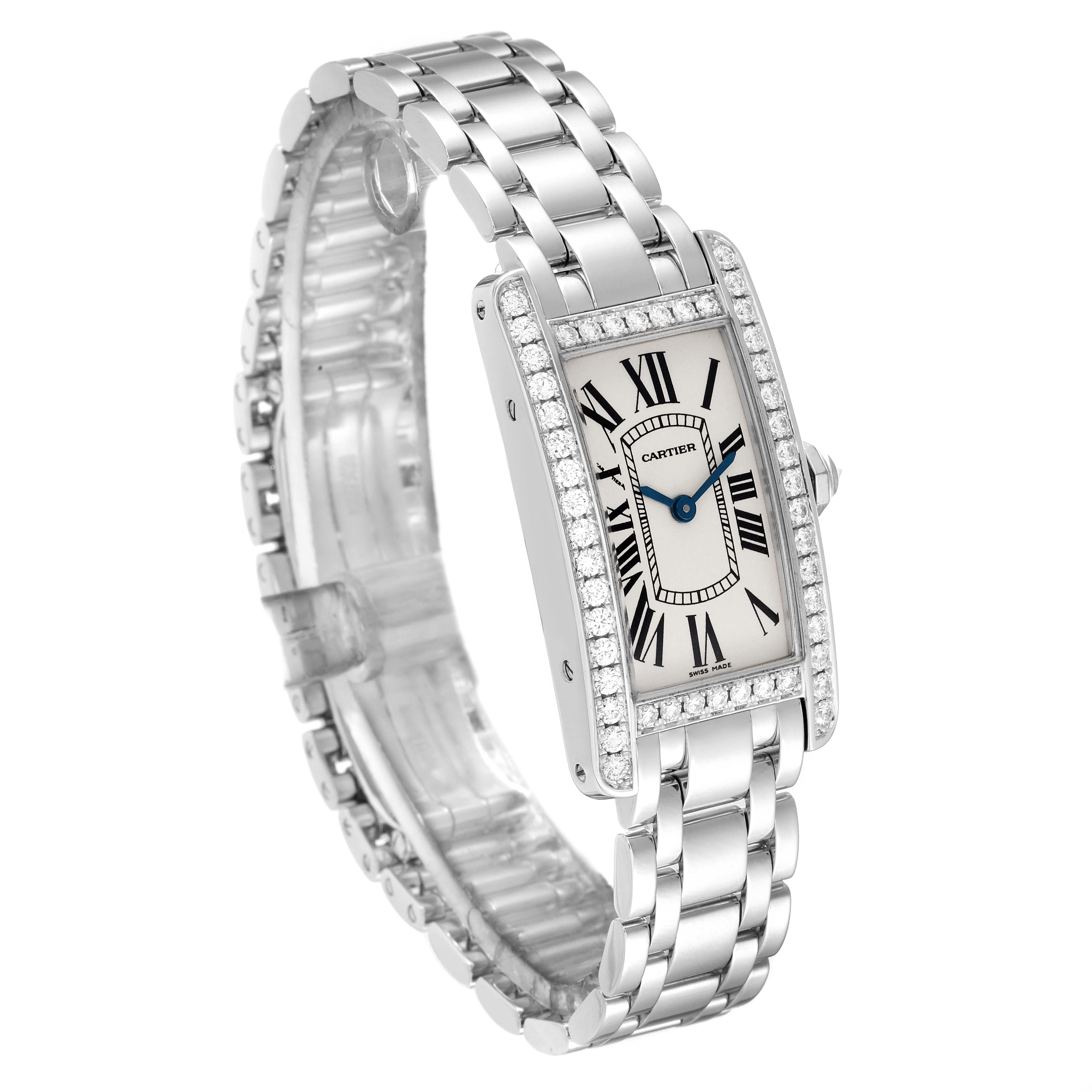 The image shows a Cartier Tank Americaine WB7073L1 Women's White Gold Silver Dial WB7073L1 Women's White Gold Silver Dial watch at a three-quarter angle, highlighting its rectangular face, blue hands, and metal bracelet.