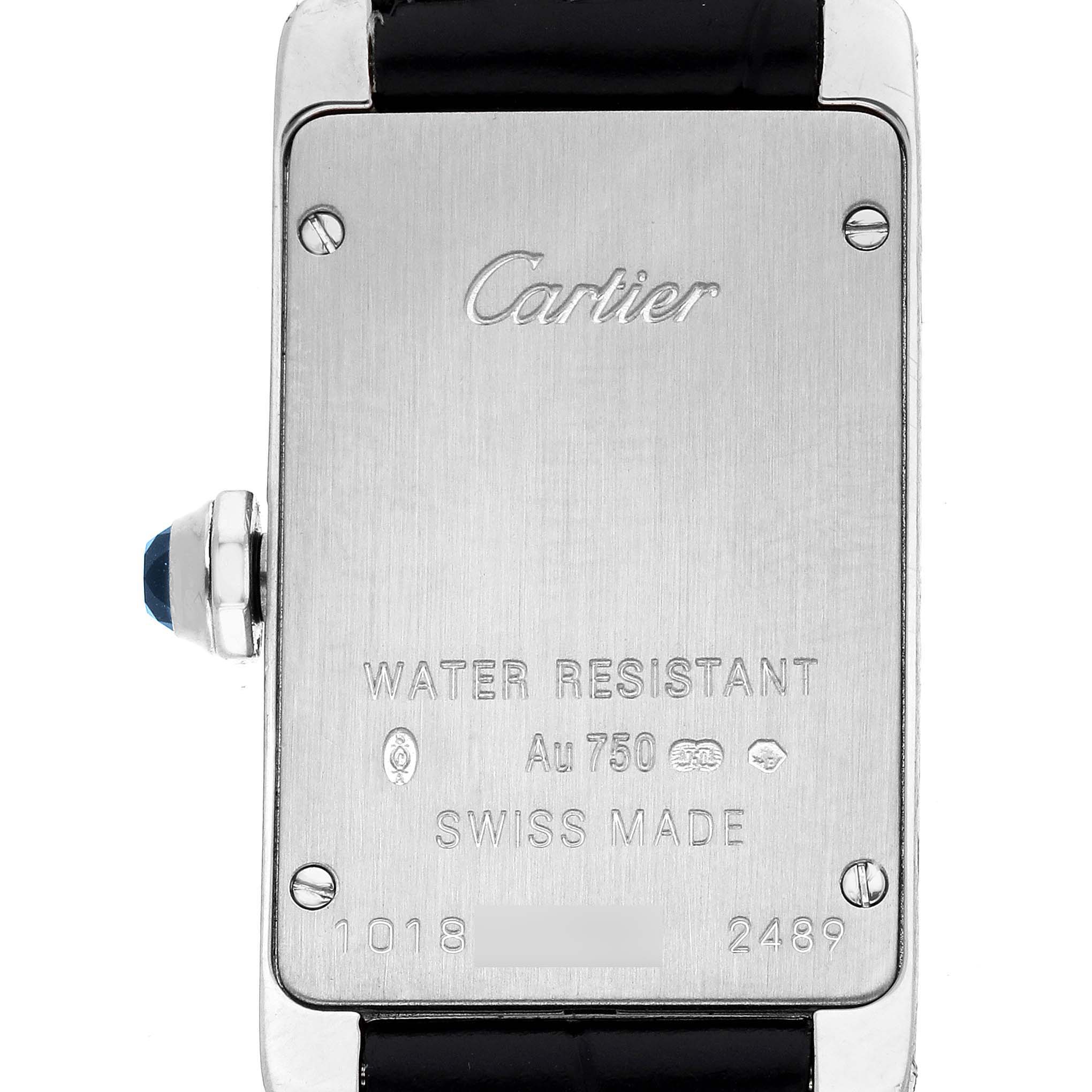 The image shows the back of the Cartier Tank Americaine W2601956 Women's White Gold Silver Dial watch, displaying brand engravings and hallmark details.