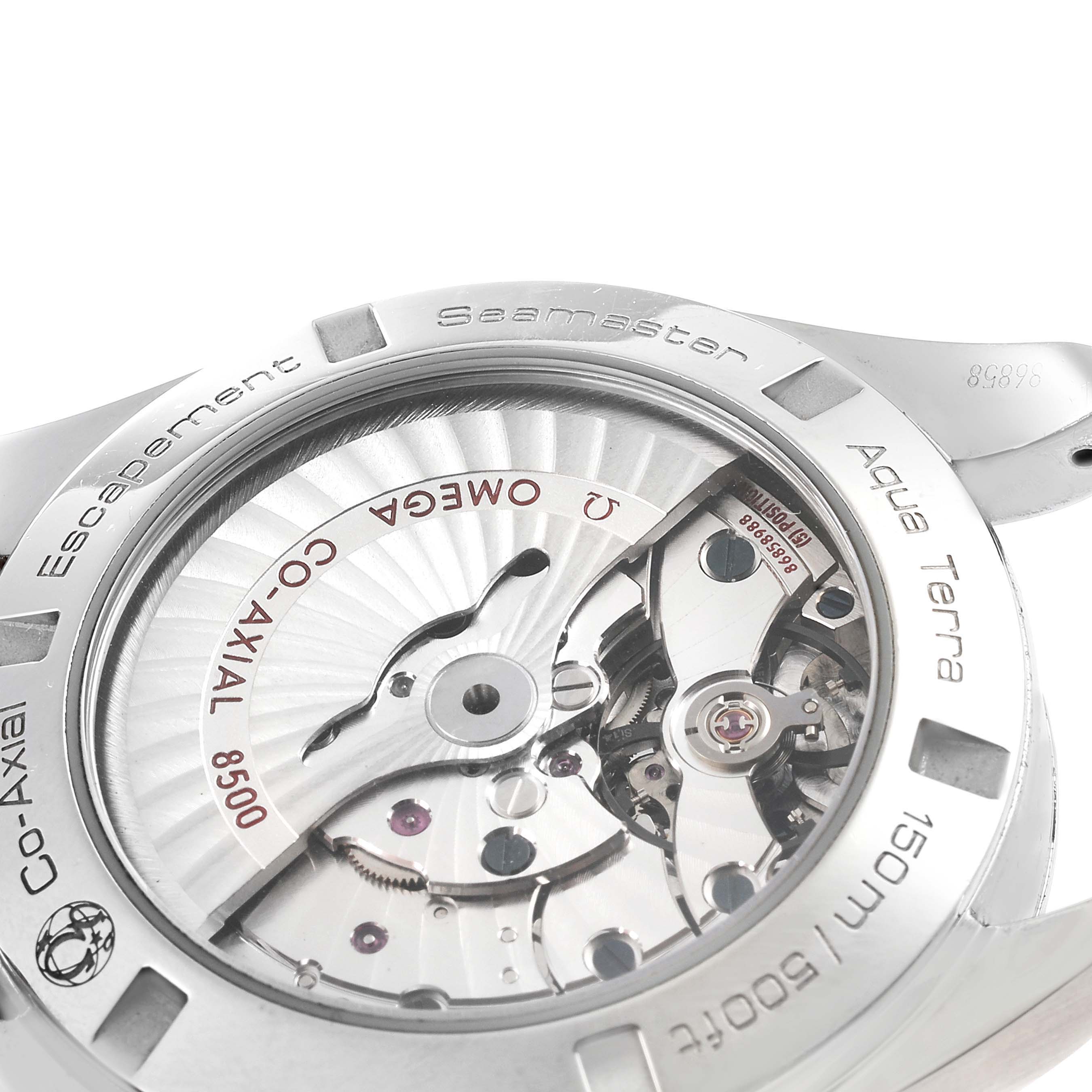The image shows a close-up of the case back of an Omega Seamaster Aqua Terra watch, highlighting its co-axial escapement mechanism.