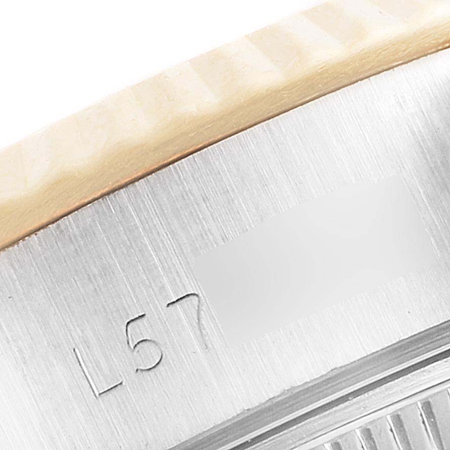 This image shows a close-up of the side view of a Rolex Datejust 69173 Women
s Steel and Gold (two tone) Champagne Dial 69173 Women
s Steel and Gold (two tone) Champagne Dial watch, highlighting its bezel and engraved serial number.