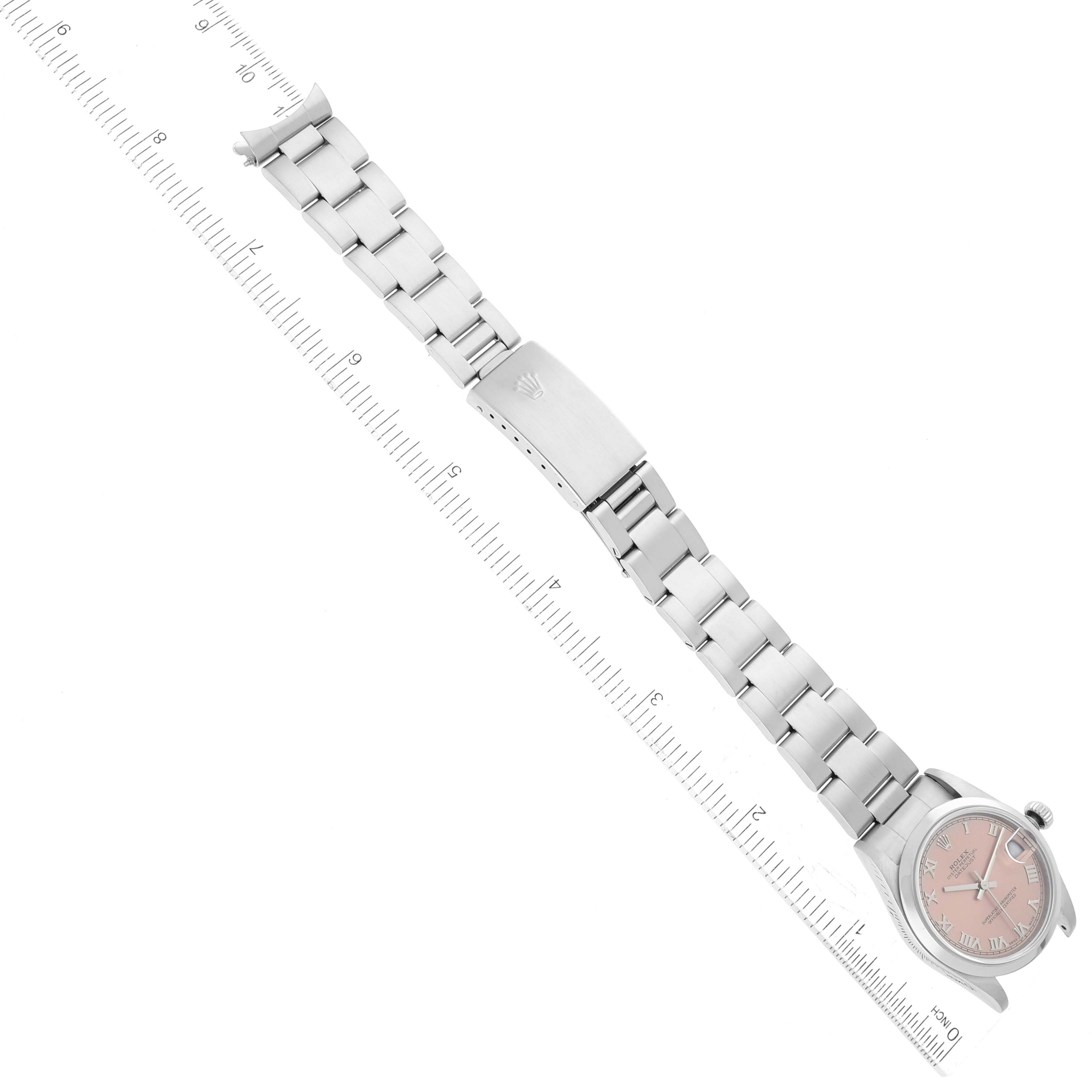The image shows a top view of a Rolex Mid-Size 78240 Women's Stainless Steel Pink Dial 78240 Women's Stainless Steel Pink Dial watch with its band extended and placed next to a ruler for scale.