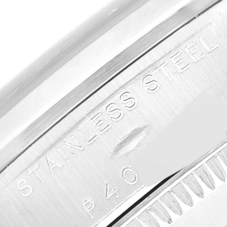 The image shows a close-up of the stainless steel casing and serial number of a Mid-Size Rolex watch.