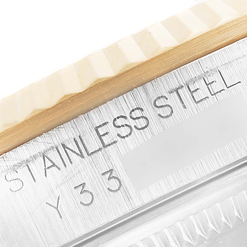 The image shows the engraved part of the case and the fluted bezel of a Rolex Datejust 16233 Men's Steel and Gold (two tone) Champagne Dial 16233 Men's Steel and Gold (two tone) Champagne Dial watch.