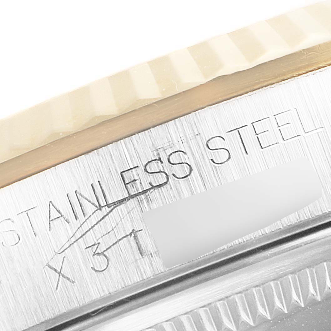 This close-up image shows the stainless steel bezel and part of the engraved case of a Rolex Datejust 16233 Men's Steel and Gold (two tone) Champagne Dial 16233 Men's Steel and Gold (two tone) Champagne Dial watch.