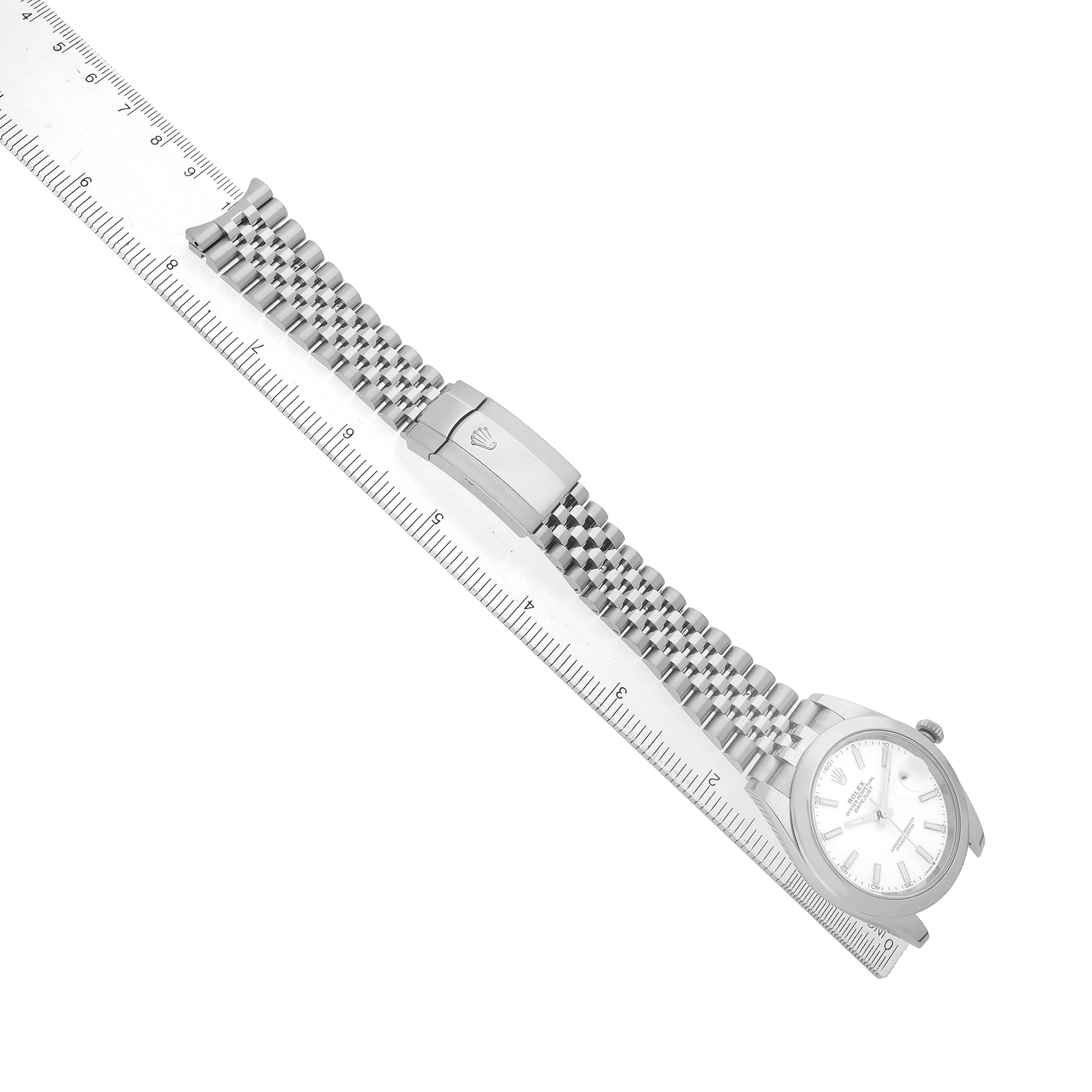 The Rolex Datejust 41 126300 Men's Stainless Steel White Dial watch is shown from an angled top view, highlighting the bracelet and clasp on a ruler.