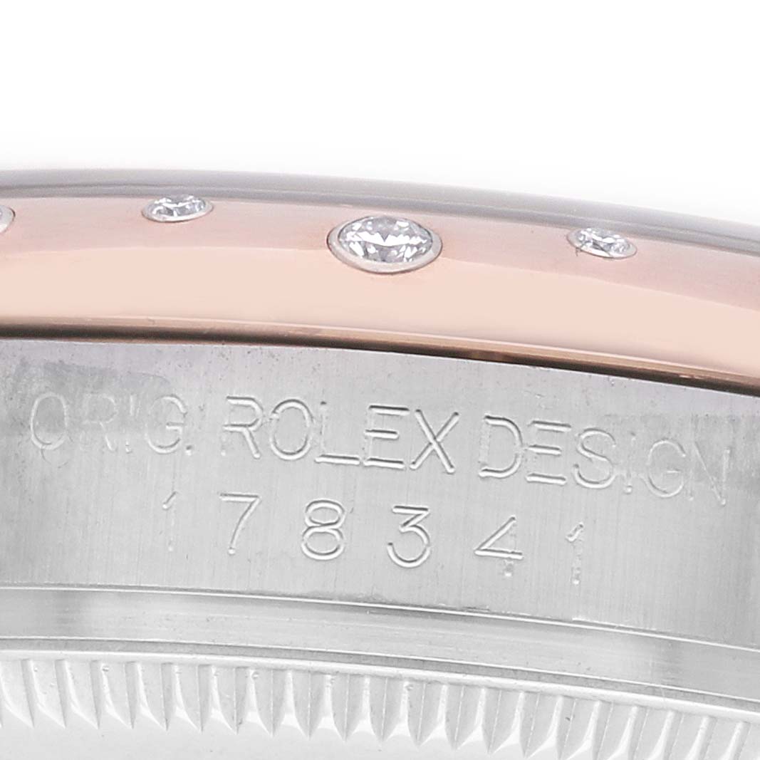 The image shows a close-up of the side of a Rolex Mid-Size 178341 Women's Steel and Gold (two tone) Silver Dial watch, featuring engraved details and embedded diamonds on the bezel.